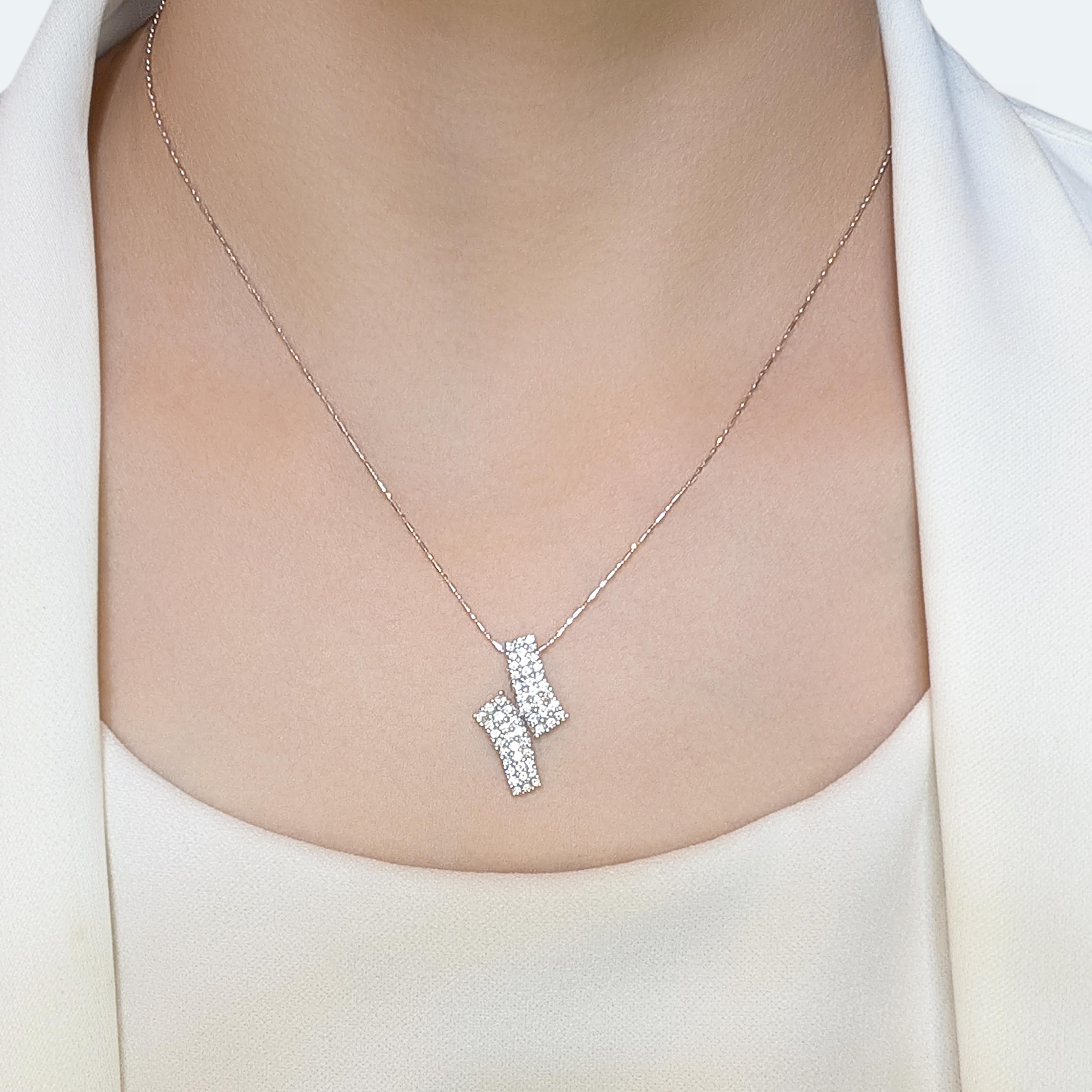 Este impresionante colgante presenta un diseño distintivo y elegante, elaborado en lujoso oro blanco de 18 quilates. Adornado con 54 diamantes brillantes redondos naturales, con un total de 0,81 ct de color F-G y claridad VS, brilla con