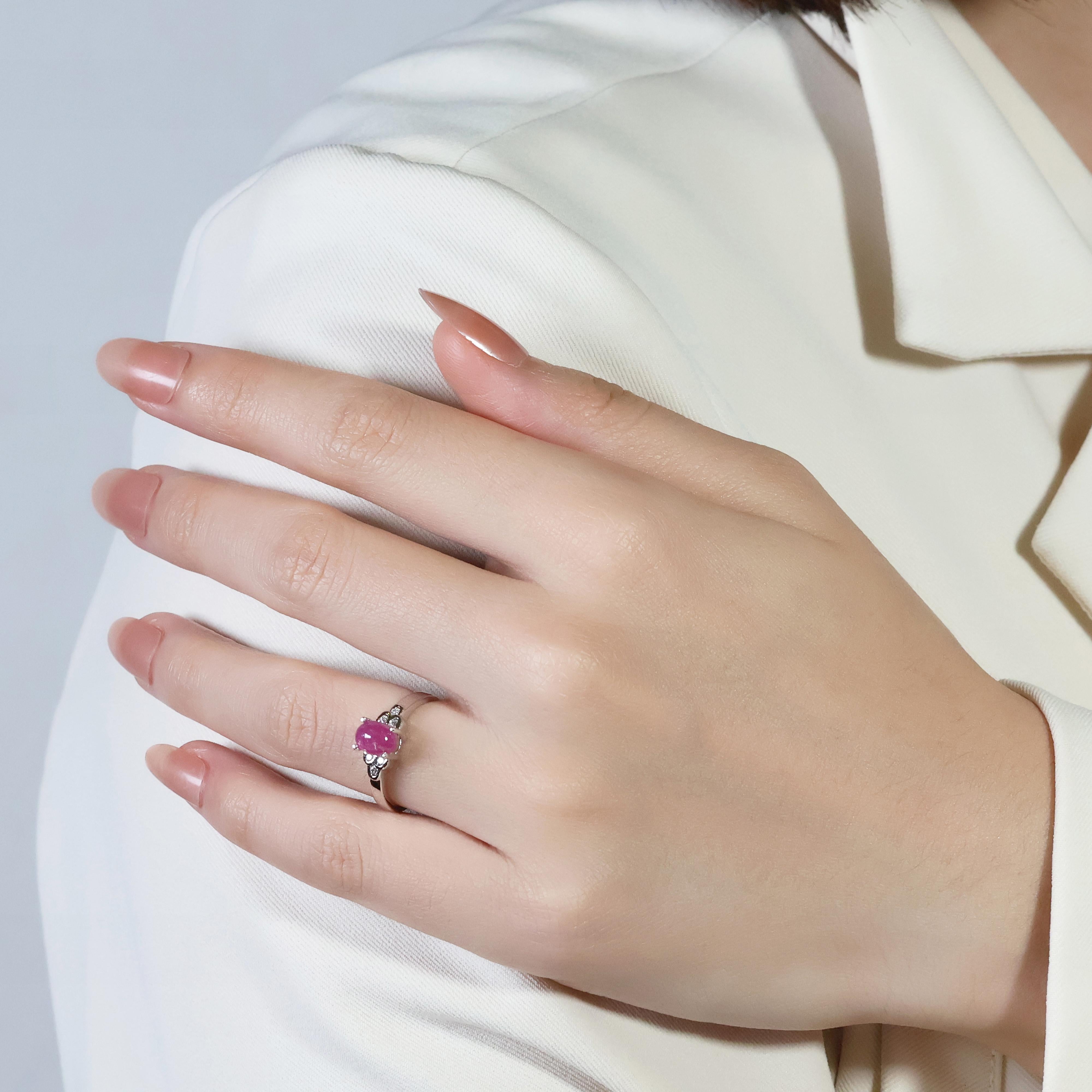 Dieser atemberaubende Ring aus 18 Karat Weißgold präsentiert einen faszinierenden roten Saphir im Cabochon-Schliff von 1,21 Karat, einen seltenen und fesselnden Edelstein. Sechs Diamanten im Brillantschliff mit einem Gesamtgewicht von 0,06 ct. und