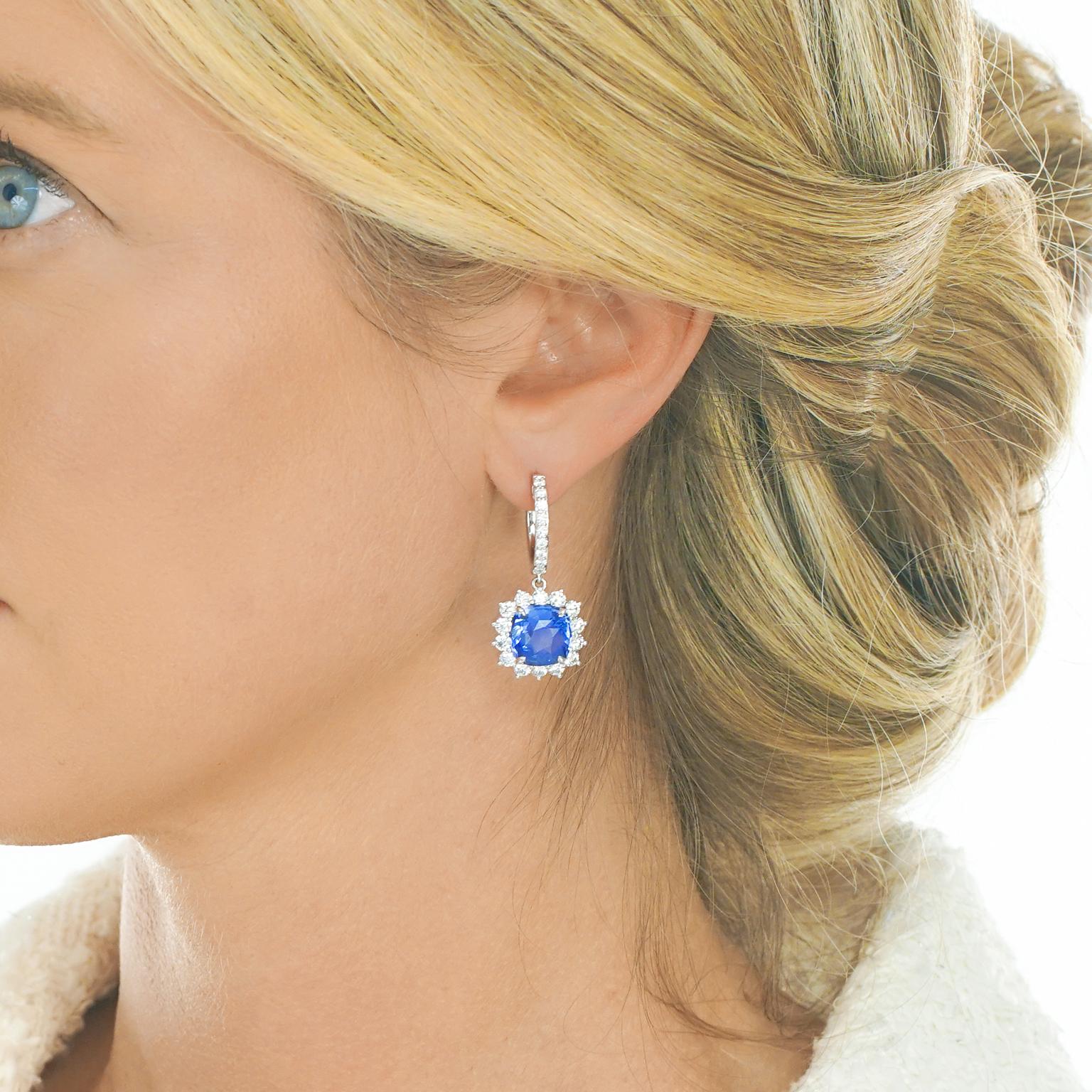 Circa 2000s, Platinum, American. Set with luminous cornflower blue sapphires (5.27ct and 5.26ct) surrounded by 2.63 carats of brilliant white diamonds, these stunning drop earrings are perfect for any special occasion. Beautifully made in platinum,