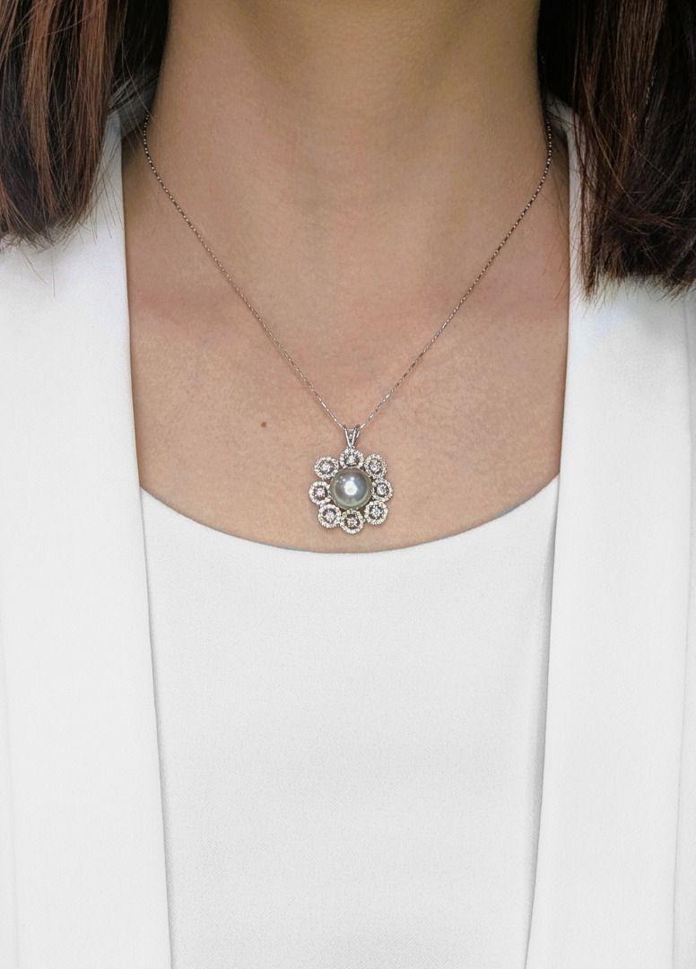 A perfect blend of sophistication and brilliance, this 18K white gold pendant showcases a stunning greenish-grey freshwater pearl, measuring 11.65mm, radiating a unique, lustrous glow. Surrounding it, 112 round brilliant-cut natural diamonds,