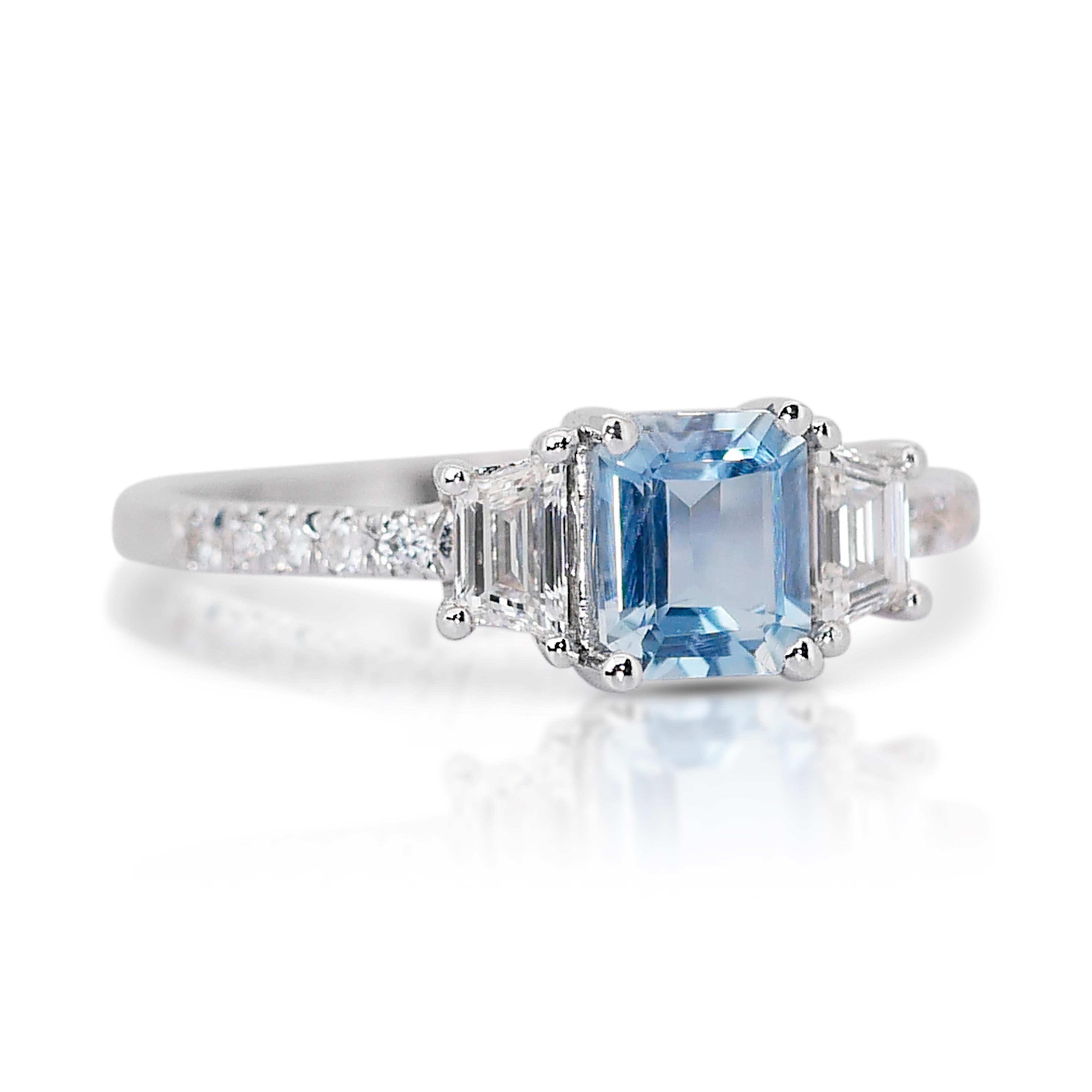 Elegant 1.28ct Aquamarine and Diamonds 3-Stone Ring in 18k White Gold - IGI Certified

This exquisite ring in 18k white gold showcases a breathtaking 0.80-carat emerald-cut aquamarine as its centerpiece. Surrounding the main stone are 2