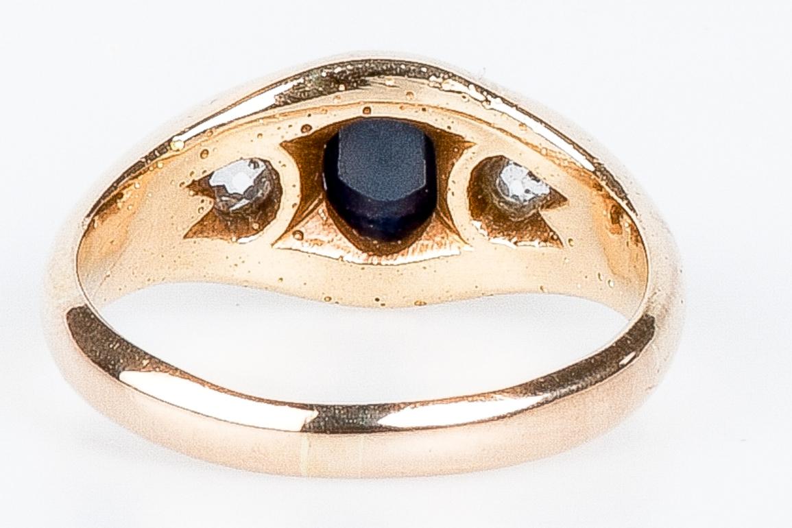 In der Mitte dieses eleganten Rings aus 14 Karat Gelbgold funkelt ein ovaler Saphir, der durch seine Tiefe und Faszination besticht. Auf jeder Seite des Saphirs befinden sich zwei Brillanten von je 0,125 Karat, also insgesamt 0,3 Karat. Diese beiden