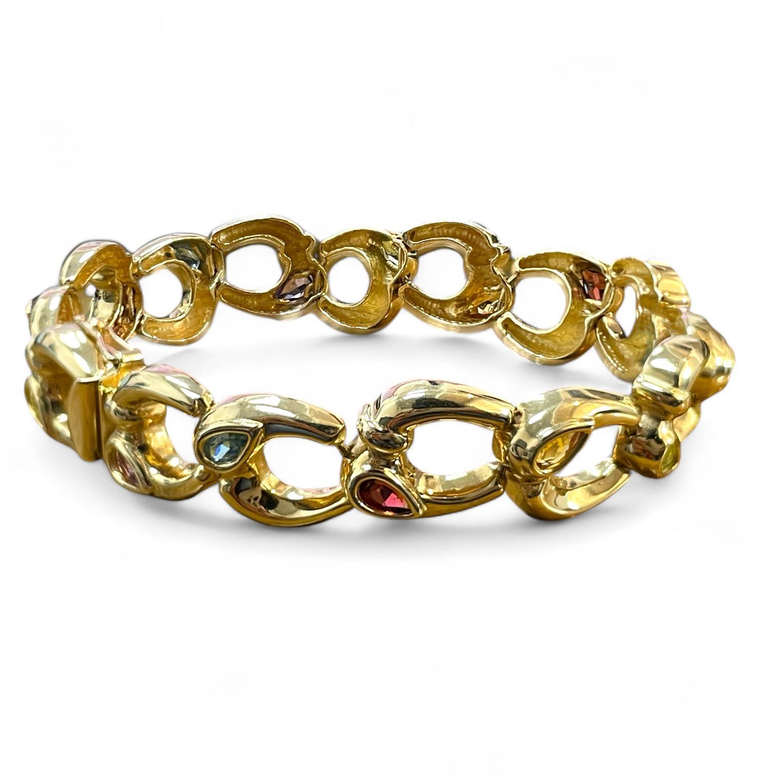 Laissez-vous séduire par le luxe de ce bracelet exquis, réalisé avec expertise en or poli et doté d'une série complexe de maillons ovales imbriqués les uns dans les autres. Chaque maillon est magnifiquement orné d'une petite pierre précieuse