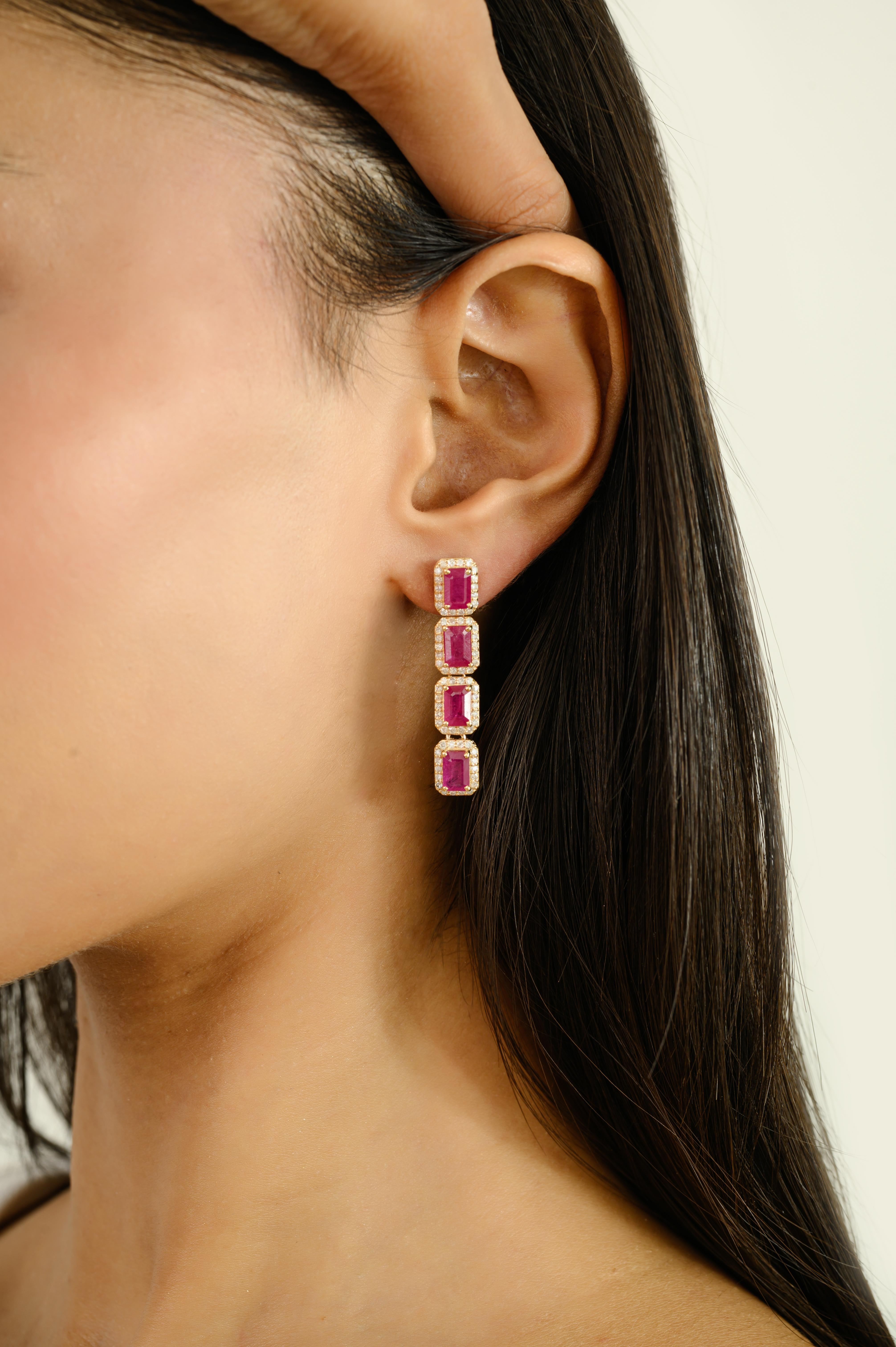 Radiating timeless elegance, these Elegant 14k Yellow Gold Emerald-Cut Ruby and Diamond Halo Long Drop Earrings are a true statement of sophistication. Each earring features a vertical row of vivid, emerald-cut rubies, meticulously framed by