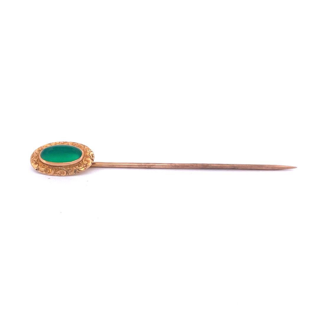 Make a statement with this elegant 14k yellow gold green chalcedony pin. The pin showcases a stunning oval-shaped green chalcedony stone at its center, surrounding the stone, intricate gold carvings in an oval shape add a touch of sophistication and