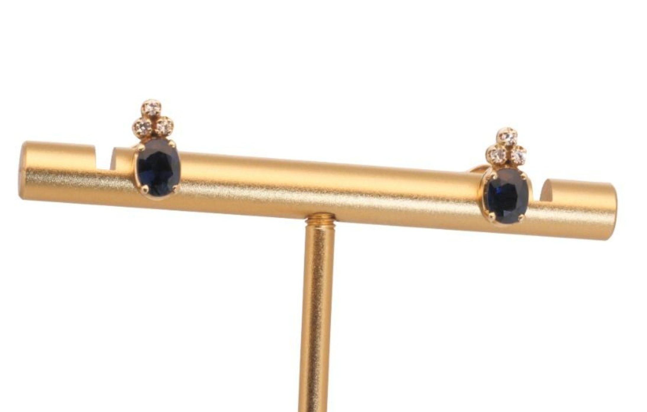 Ein schönes Paar Ohrstecker mit einem schillernden 1,4 Karat  natürlicher Saphir. Er hat 0,06 Karat seitliche Diamanten, die seine Eleganz noch unterstreichen. Der Schmuck ist aus 14k Gelbgold mit einer hochwertigen Politur gefertigt. Es wird mit