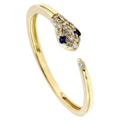 Elegante bague en or jaune 14KT à motif de serpent avec diamants et saphir bleu