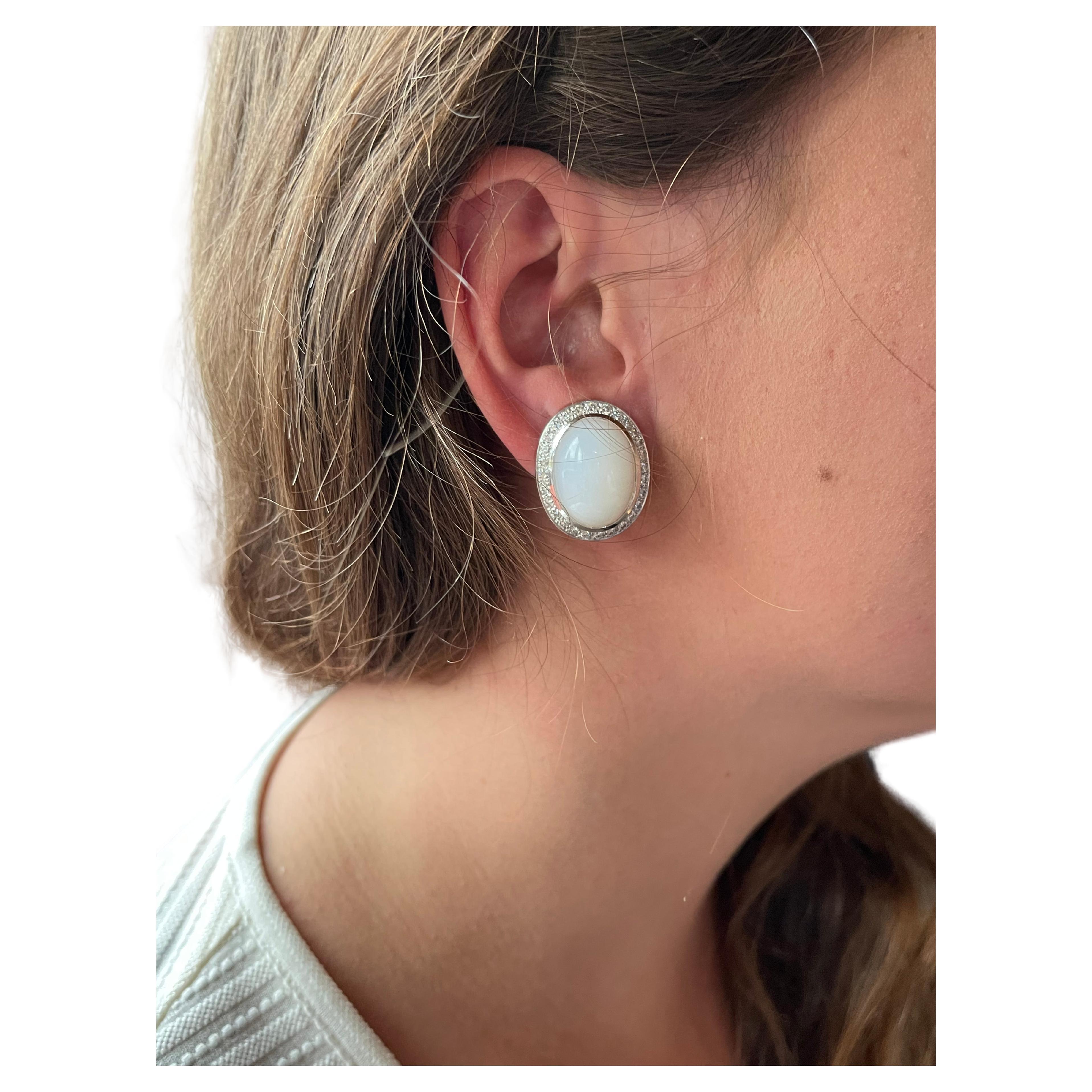 Elegant 18 K white Gold earclips featuring 2 lovely Moonstone Cabochons weighing 30.91 ct and surrounded by 56 brilliant cut Diamonds with a total weight of 1.96 ct, G color, vs clarity. 
Masterfully handcrafted piece! Authenticity and money back is