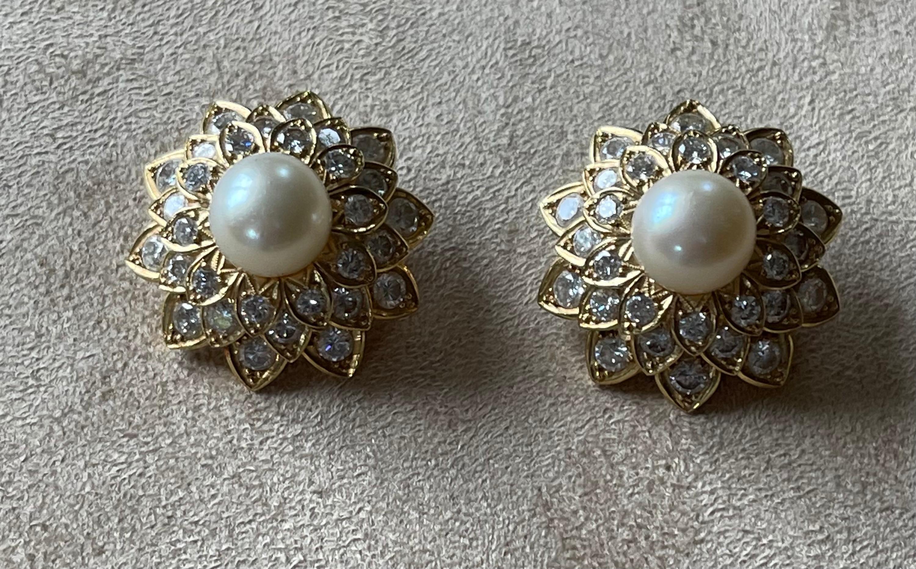 A pair of very elegant solid 18 K yellow Gold earclips designed as a stylised flower featuring 2 Akoya cultured pearls measuring ca. 9.5 mm and the petals set with brilliant cut Diaomds weighing approximately 4.50 ct. 
Measurment: Diameter ca. 2.5