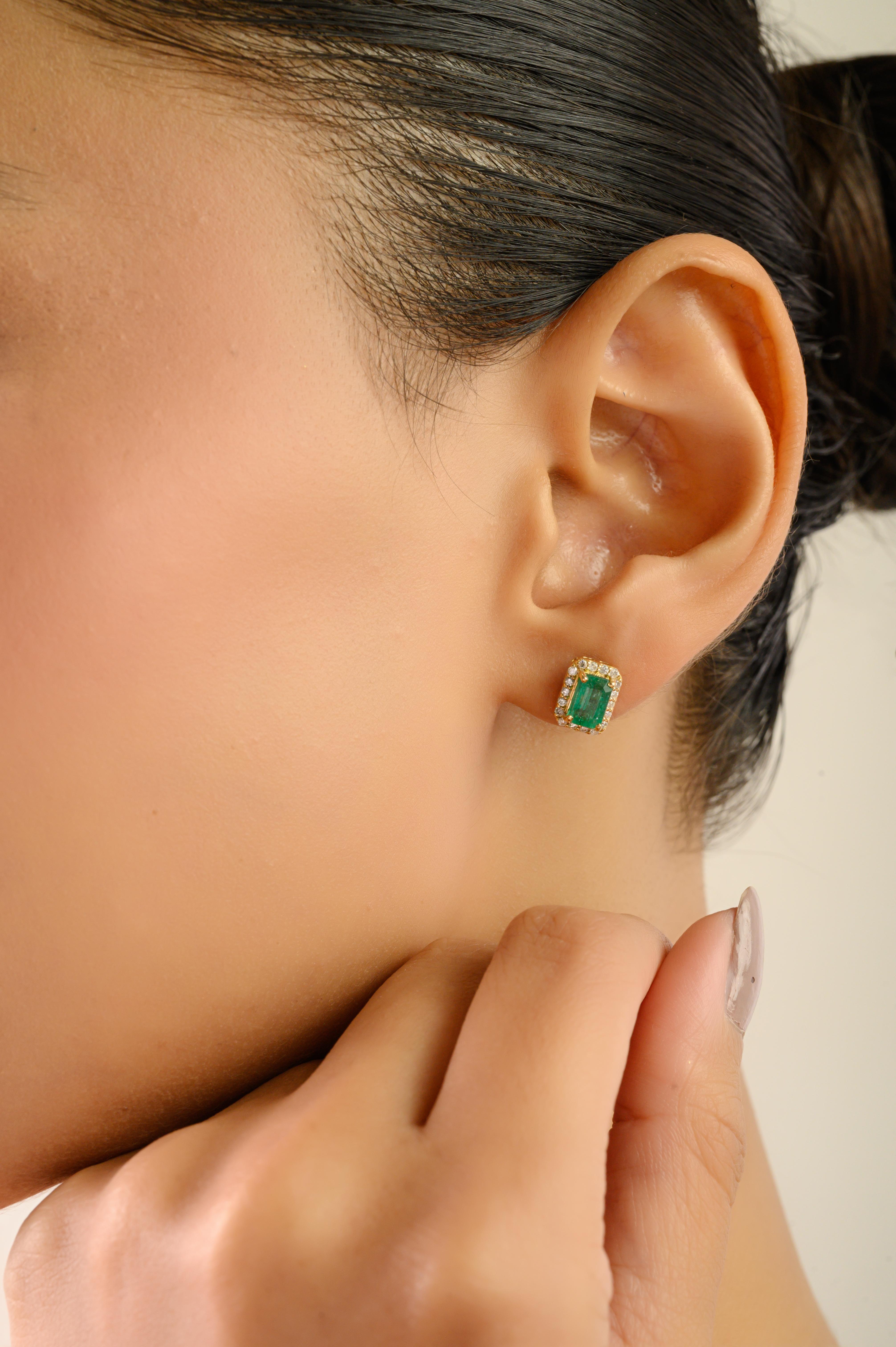 Eleganti orecchini con 1,83 carati di smeraldi dello Zambia tagliati nella classica forma a smeraldo. Ogni smeraldo è circondato da un'aureola di diamanti rotondi taglio brillante da 0,23 carati, incastonati in oro giallo 18 carati. Gli orecchini