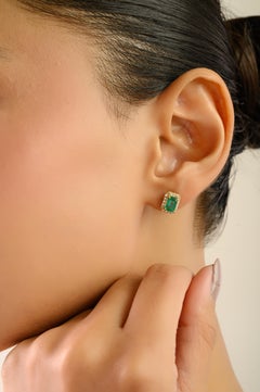 Elegantes pendientes de esmeralda zambiana de 1,83 quilates con halo de diamantes en oro amarillo de 18 quilates