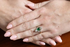 Elegant 18k gold ring with a central emerald and old brilliant-cut diamonds.