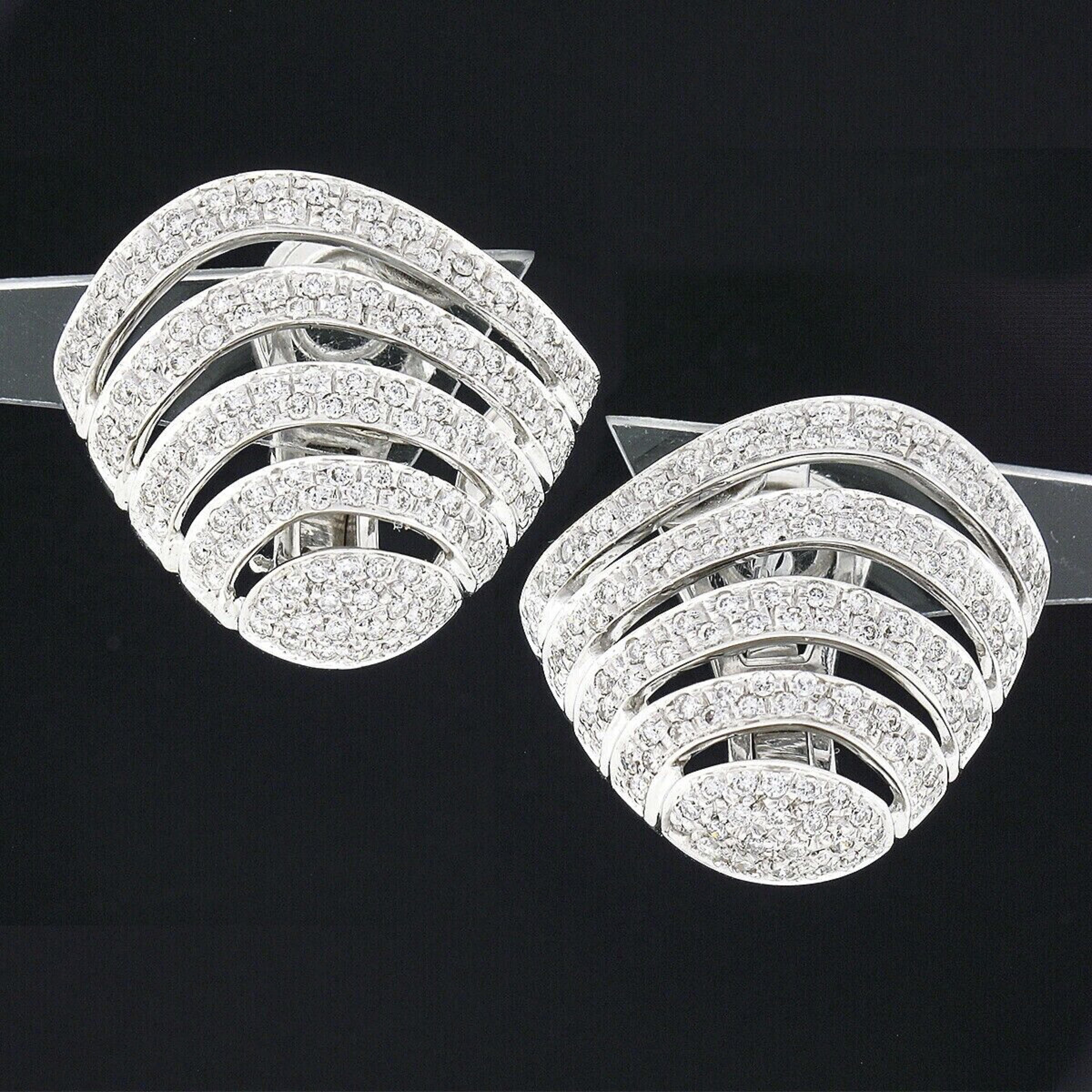 Here we have an absolutely elegant looking pair of earrings crafted in solid 18k white gold. They feature a beautiful open shell-shape design that is completely drenched with round brilliant cut diamonds throughout. These very fine quality diamonds