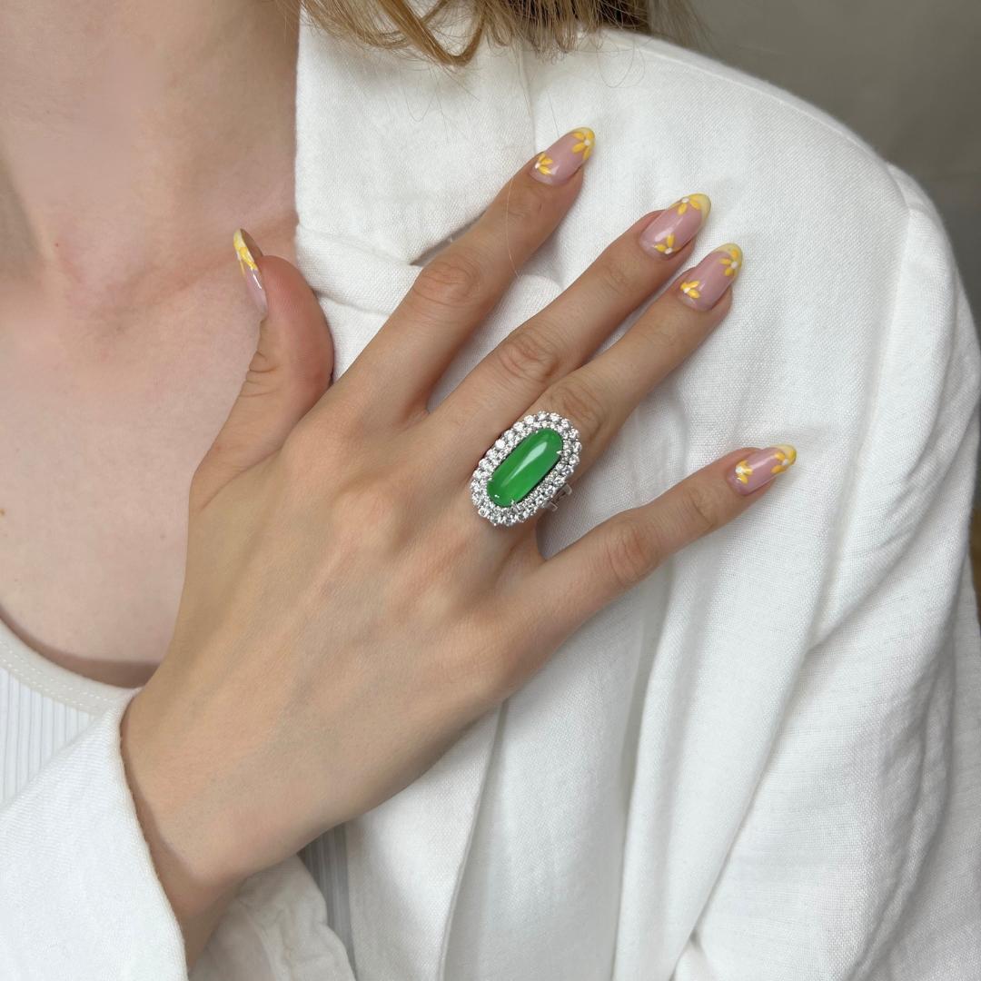 Elegant 18k White Gold Jade & Diamond Halo Ring w/5.45 ct - IGI Certified

Discover the epitome of sophistication with this exquisite 18k white gold halo ring, showcasing a stunning 3.25 carat oval-shaped jade, radiating a captivating green hue that
