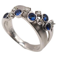 Elegant 18K White Gold Wave Ring with Sapphire and Diamonds