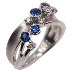 Elegant 18K White Gold Wave Ring with Sapphire and Diamonds