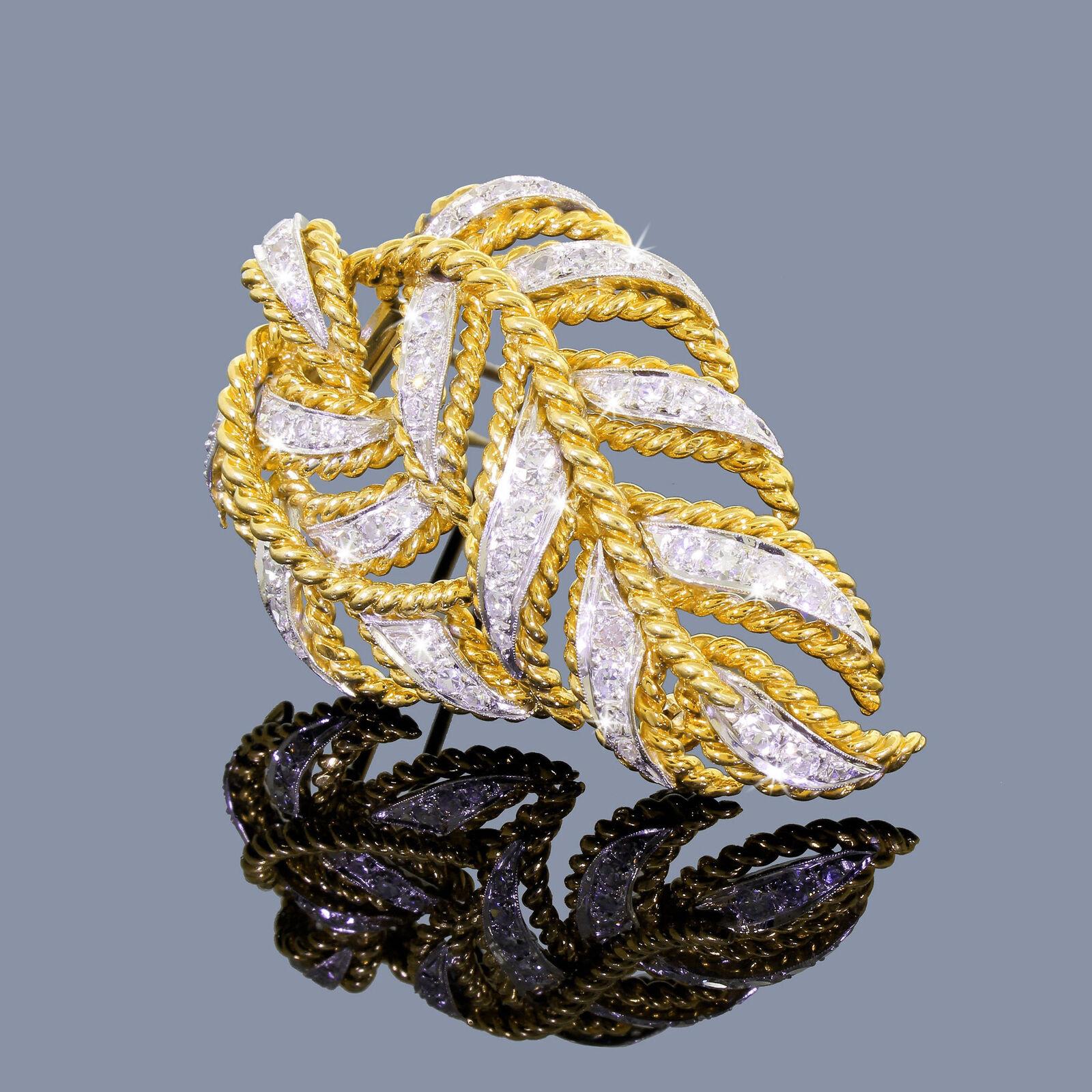 Presenting a dazzling and impressive pave diamond brooch featuring cascading falling leaves on a double branch. Accented with intricate gold spiral wire work, the brilliant cut diamonds are beautifully set in a delicate white gold frame. This