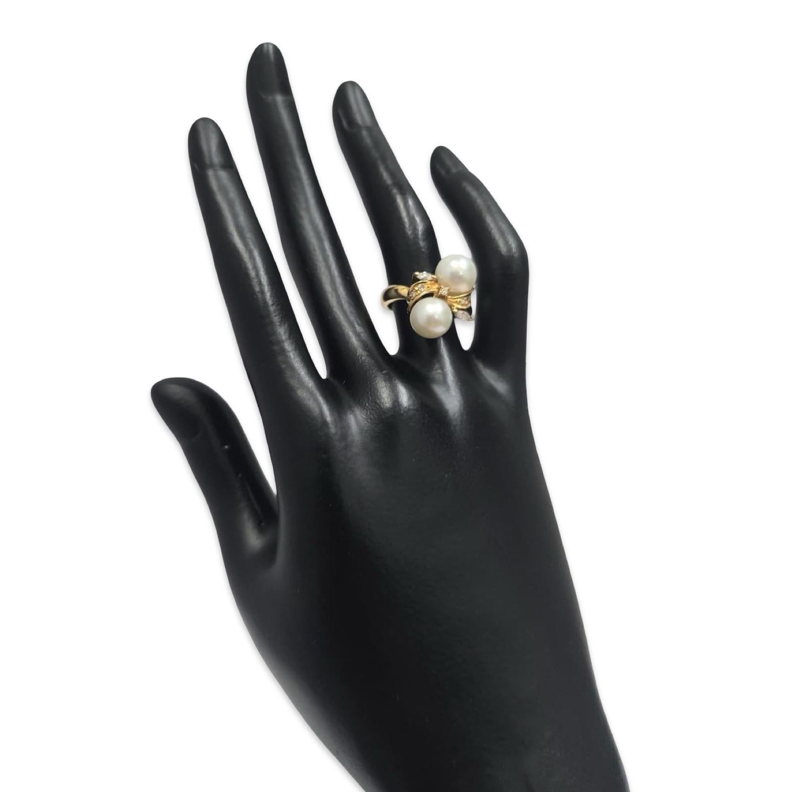 Une élégante bague bypass en or jaune 18 carats mettant en valeur deux perles de culture lumineuses mesurant 8,6 mm et 8,25 mm. Le design est rehaussé de diamants ronds de taille brillant totalisant 0,054 carats et de diamants de taille marquise