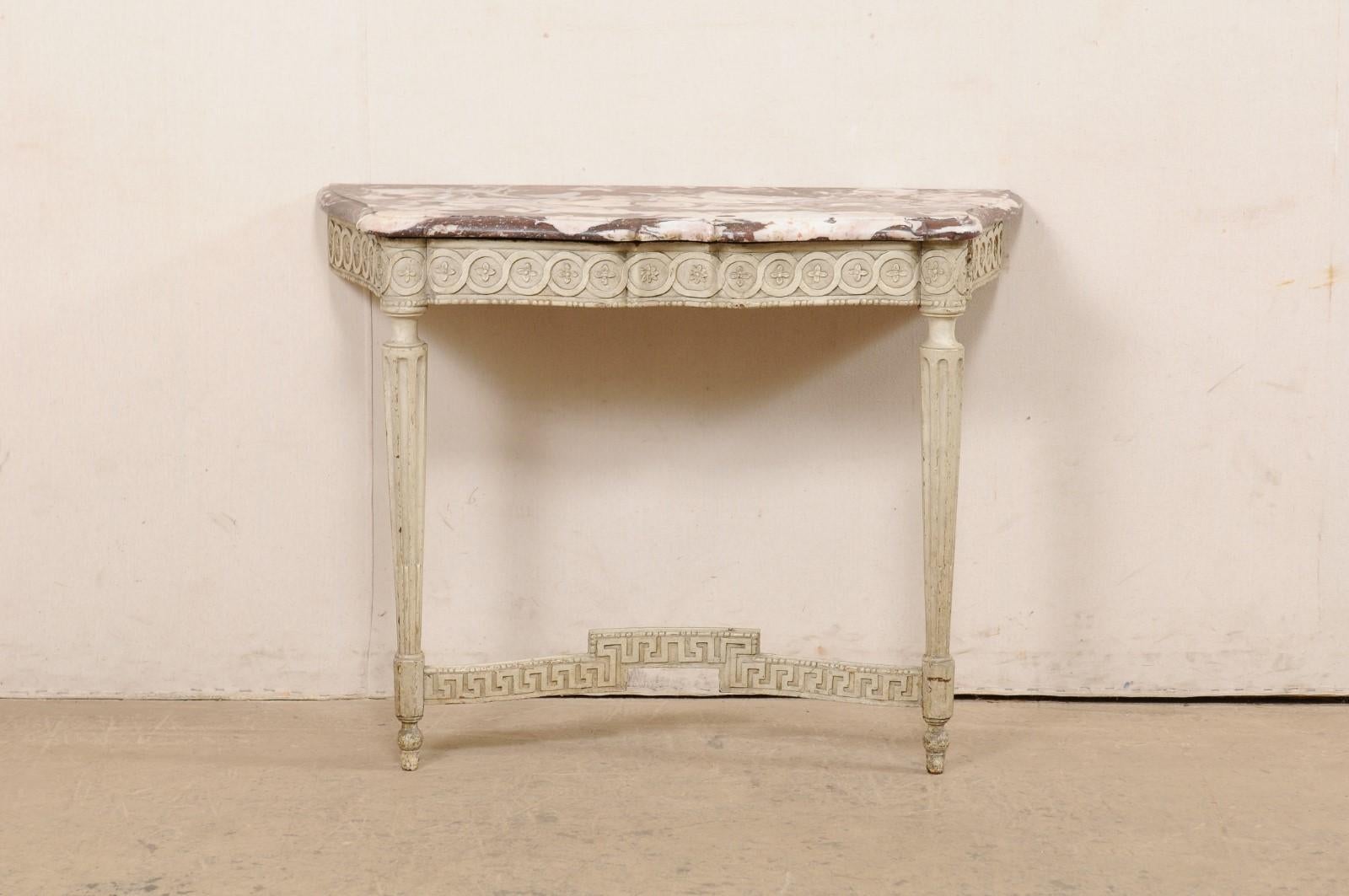 A French wall console, with its original marble top, from the 18th century. This antique table from France is beautifully curvaceous with an accolade style serpentine-shaped front and shapely sides. The original marble rests upon an apron