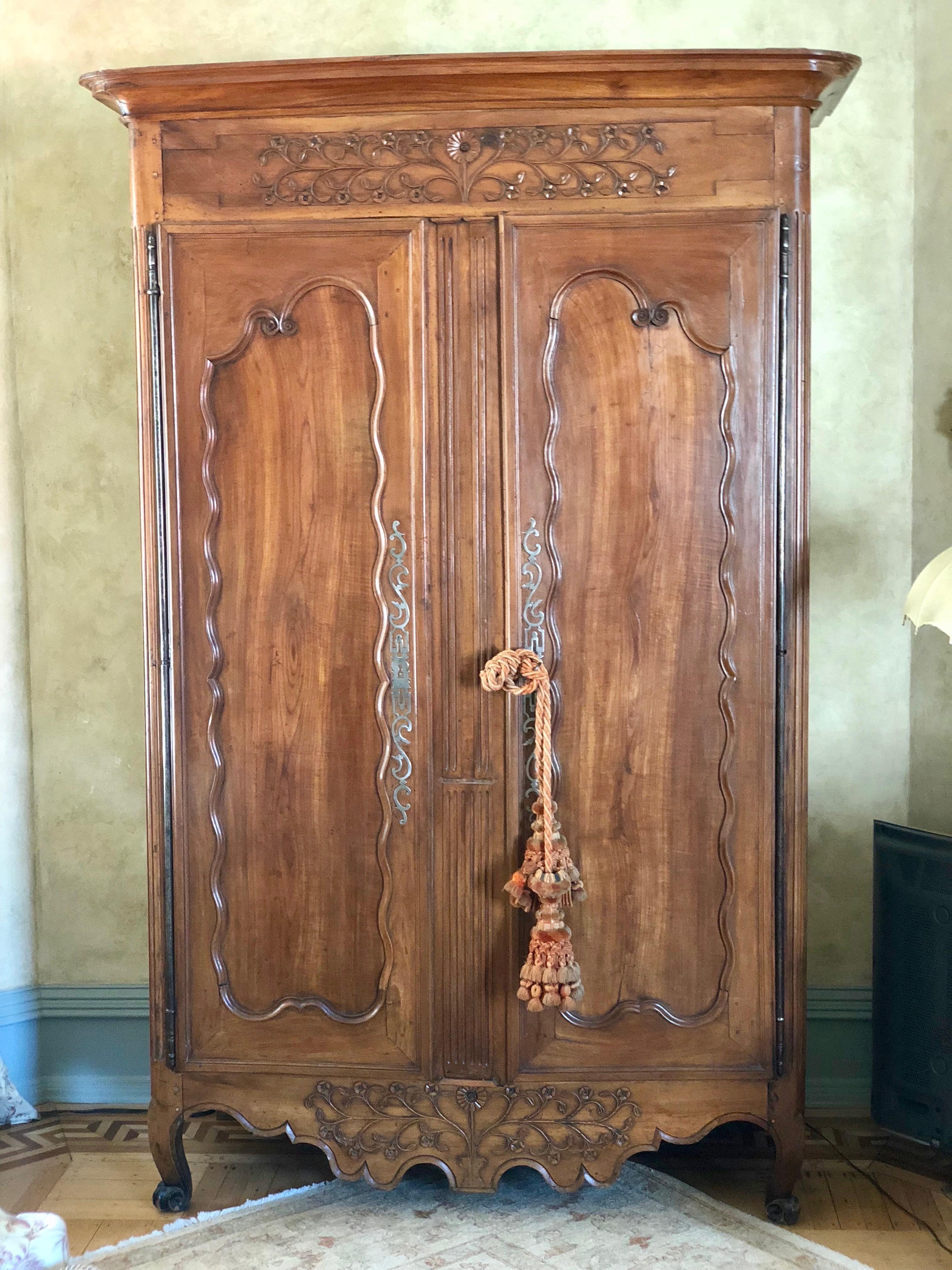 Two-door French Provincial cabinet with exposed antique brass hinges, filigree key plates.  Please note there is no key.
Inset panel doors with scrolling beaded frame, carved floral motif across frieze and shaped apron, and cabriole front feet,