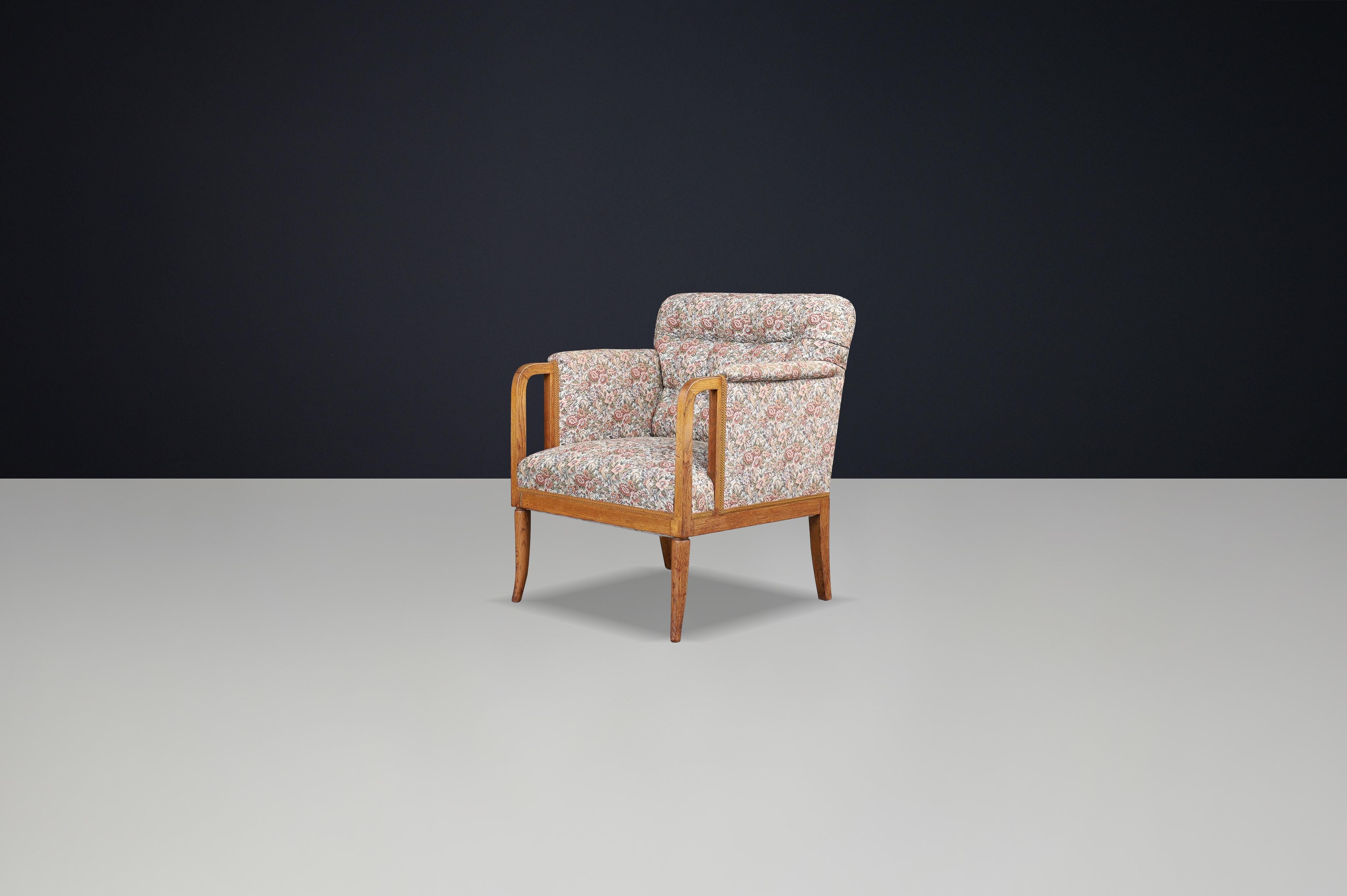 Eleganza della poltrona francese Art Deco degli anni '30 in Oak con tappezzeria floreale originale 

Questa squisita poltrona proviene dalla Francia, risale al periodo Art Deco degli anni '30 e rappresenta una miscela armoniosa di artigianato,