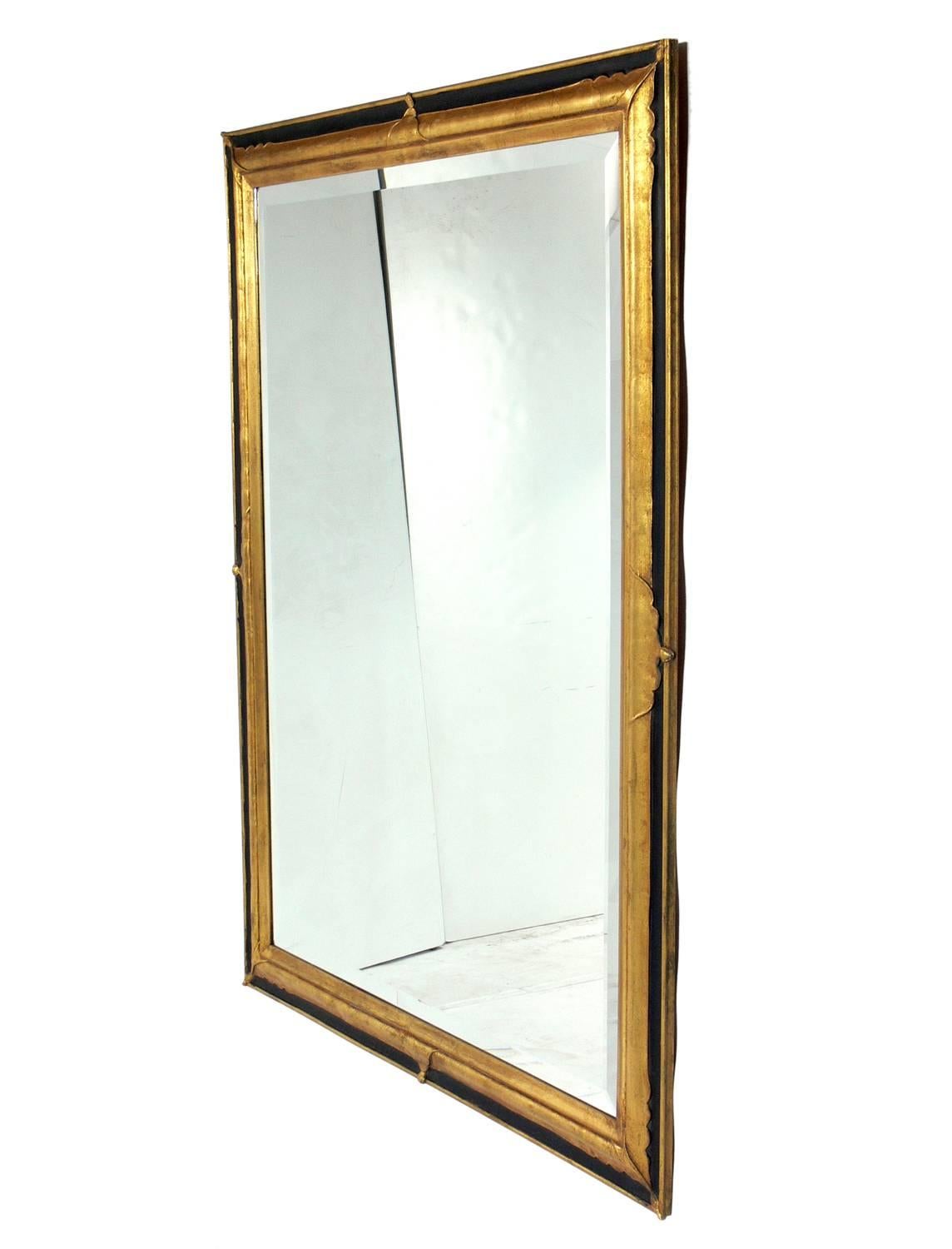 Elegant black and gilt mirror, American, circa 1940s. Retains warm original patina. This mirror can be hung vertically or horizontally, just let us know which you prefer.