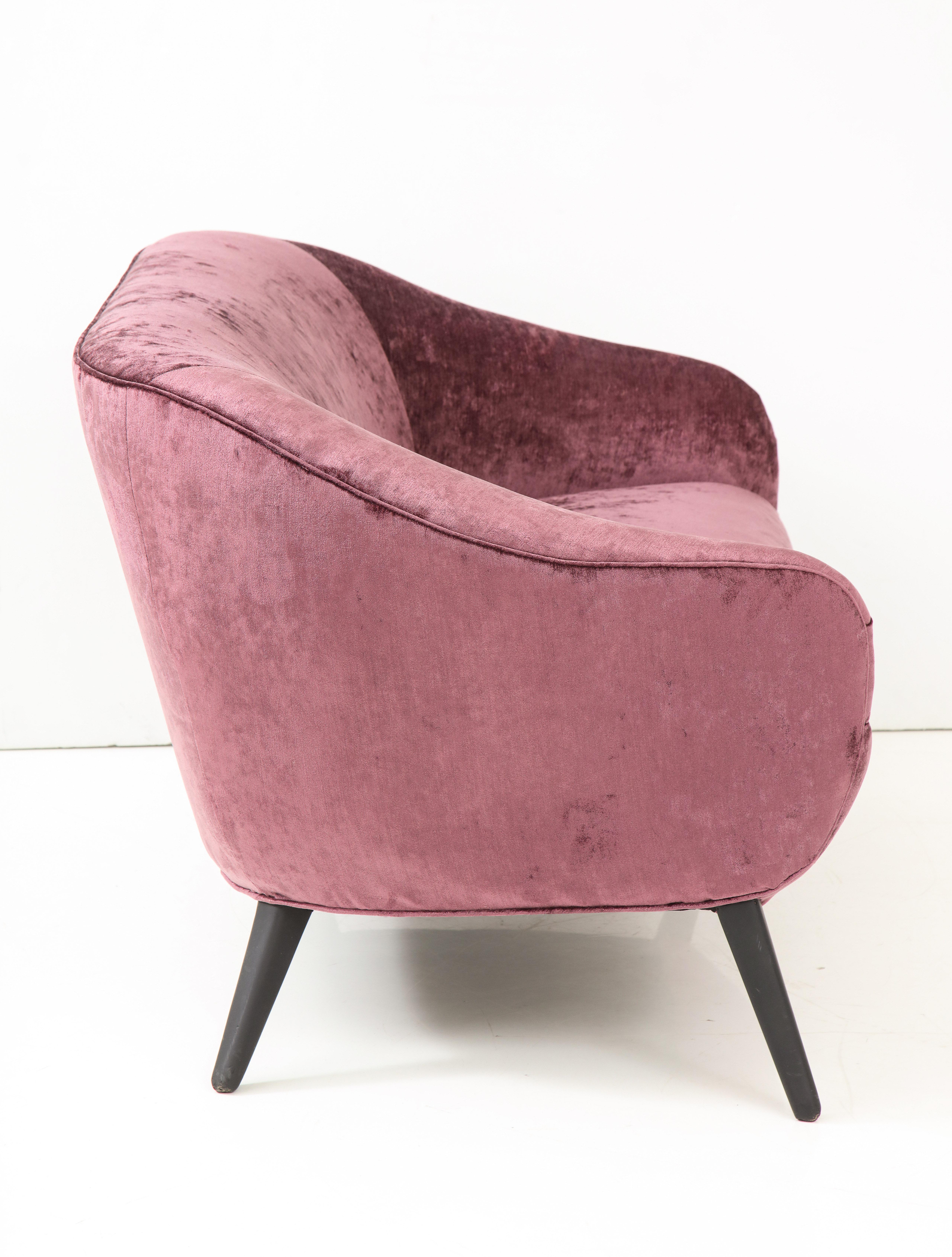 Elegant 1950s French sofa which has been beautifully reupholstered in a Rose colored chenille velvet fabric. The sofa has two separate throw pillows.
