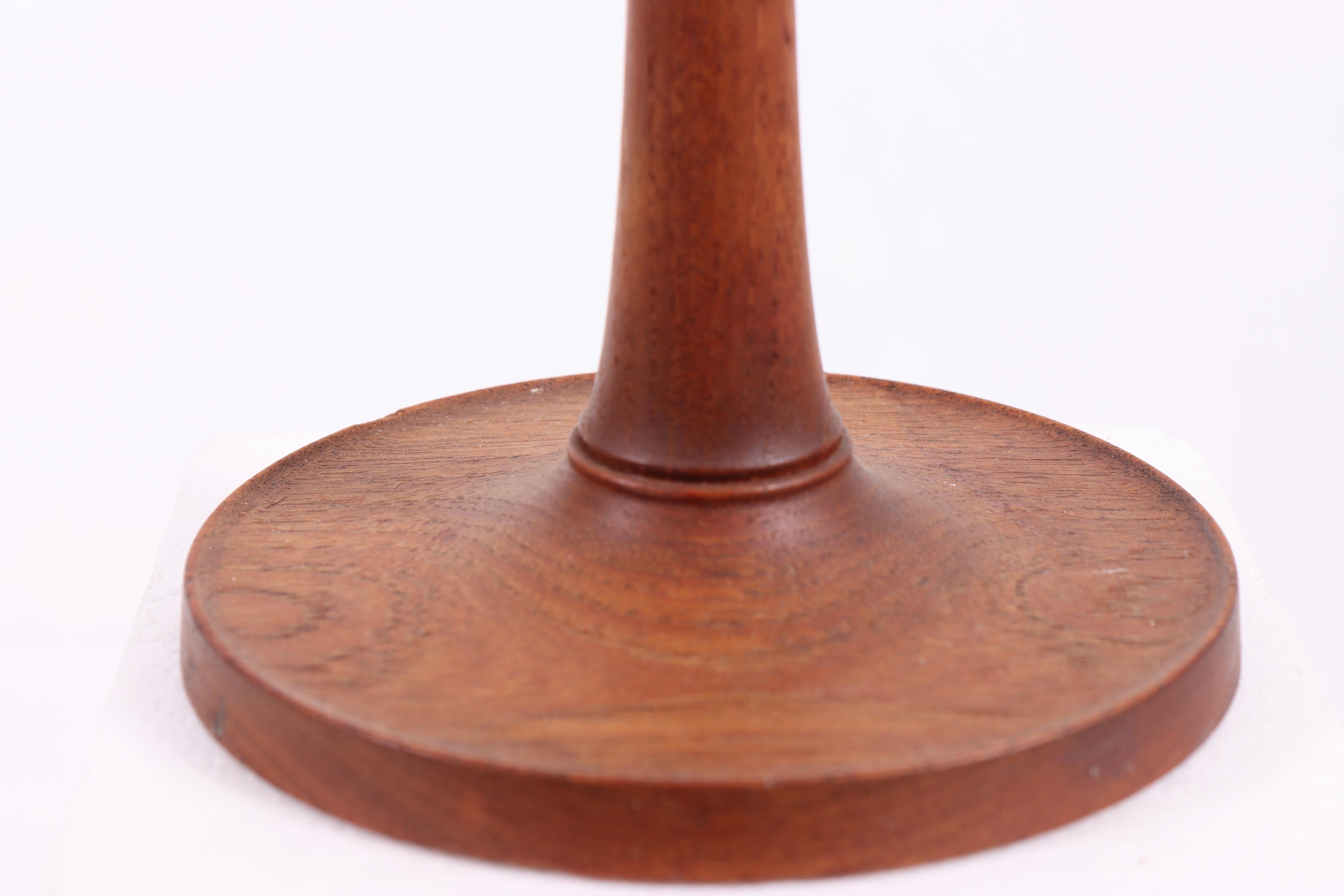 
This lamp is a beautiful example of classic Scandinavian design, created by Leklint, a renowned producer of timeless lamps. The lamp features a base made of teak wood, with a warm, natural finish that highlights the wood's fine grain. The lamp’s