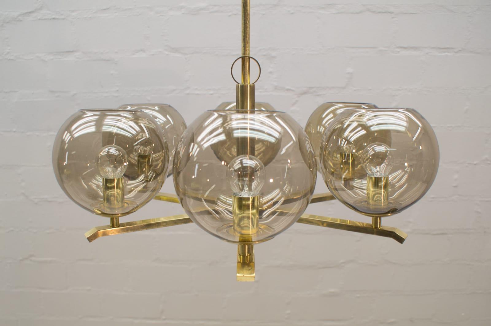 This eight-armed ceiling light was produced in Germany between the 1950s and 1960s. The lamp has its original wiring and requires eight E14 Edison screw fit bulbs. Each lamp shade measures 14 cm.