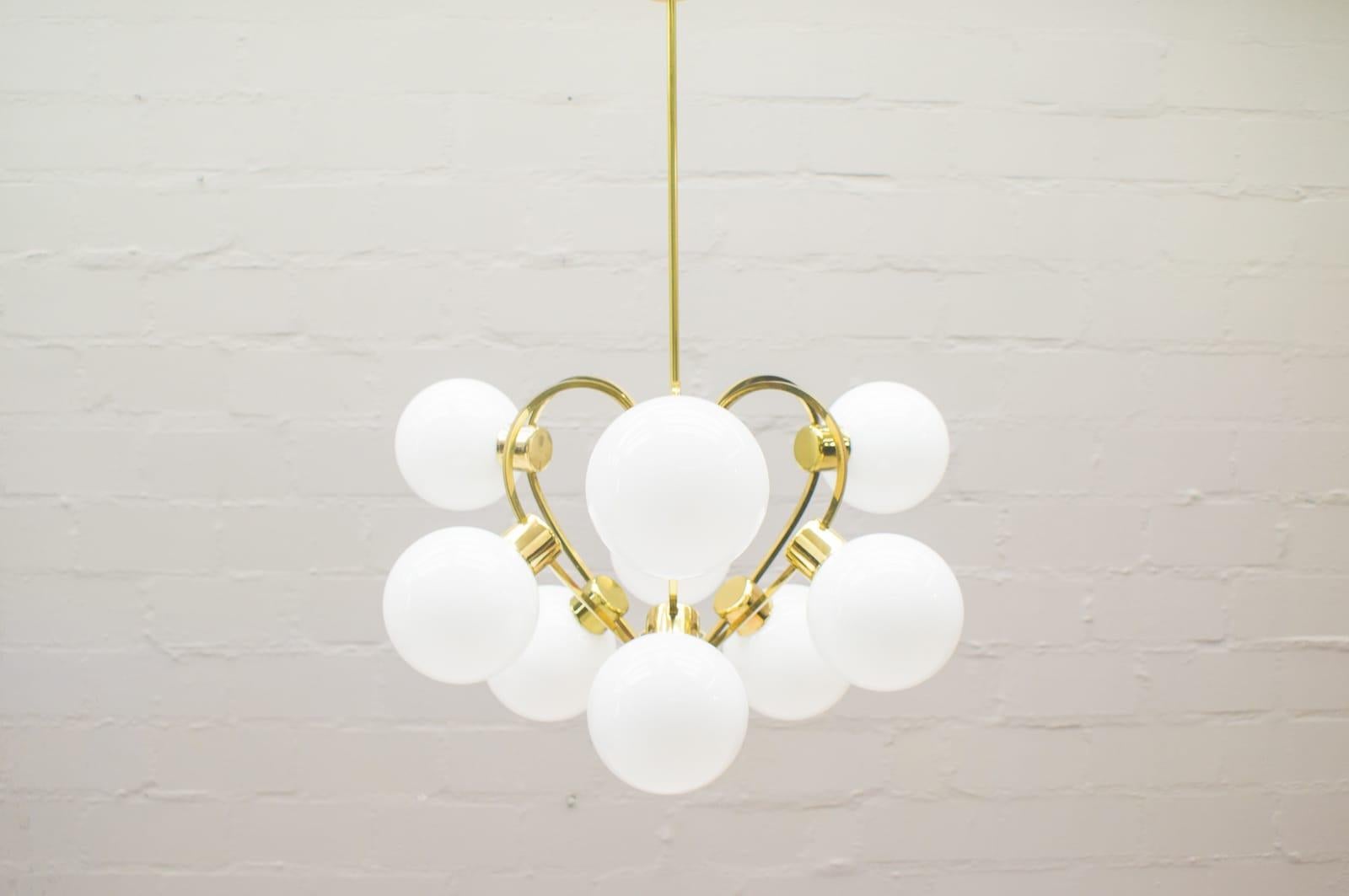 This piece is a golden 9-arm orbital Lamp with white opaline glass beads from the 1960s. It has an E14 socket.

Very elegant and decorative.