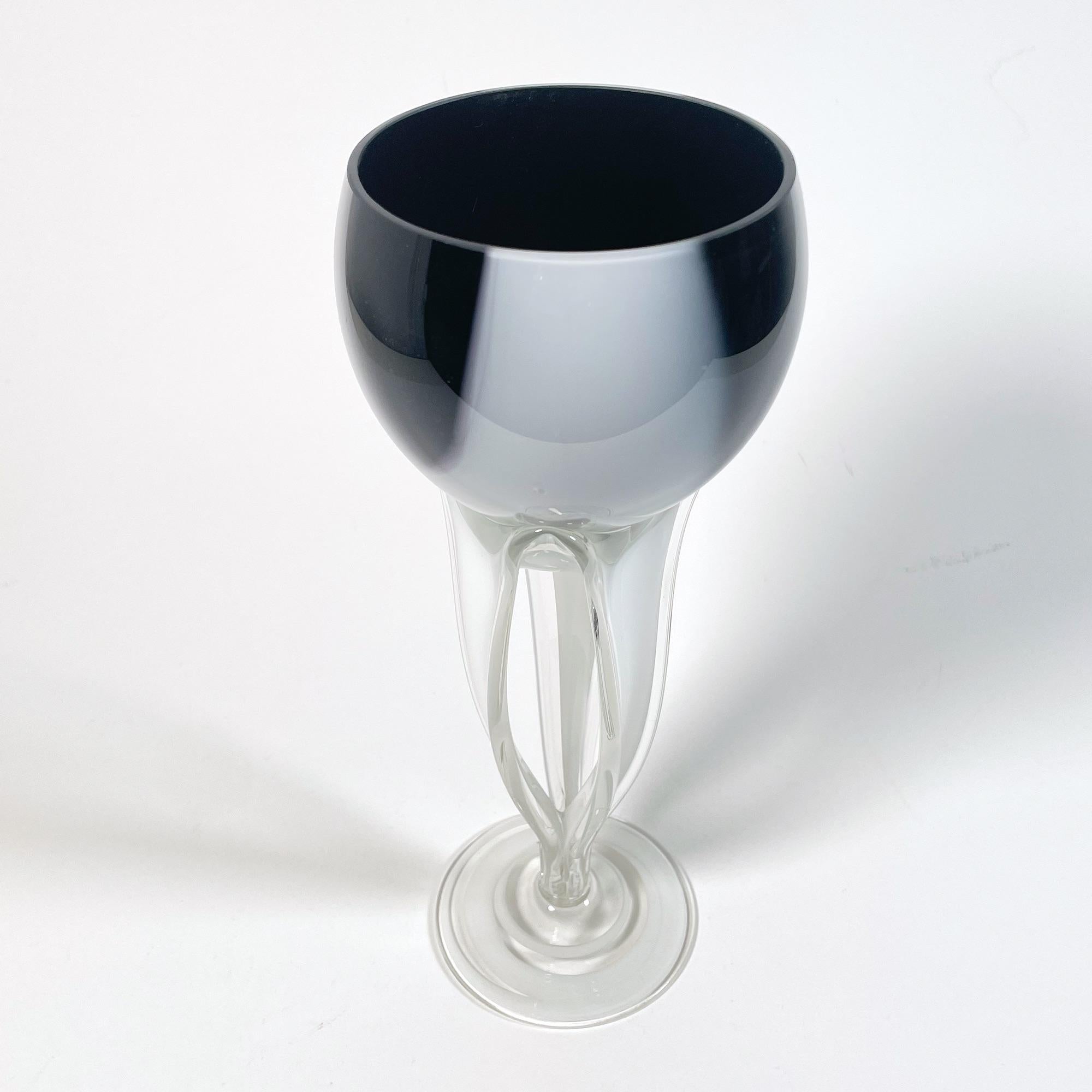 Ce bol exquis en verre de Murano, fabriqué dans les années 1960, est une représentation étonnante de l'art italien. D'une hauteur de 26 cm et d'un diamètre de 10,5 cm, cette pièce unique présente un design captivant en noir et blanc qui allie sans