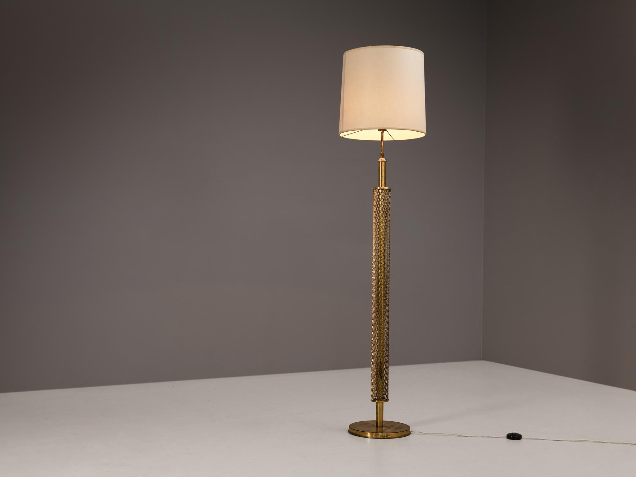 Floor lamp, brass, fabric, Europe, 1970s

The most interesting feature of this elegant floor lamp is the brass base with mesh detailing. The patinated brass enhances the warm and rich look of the material. The elegant design is completed with a