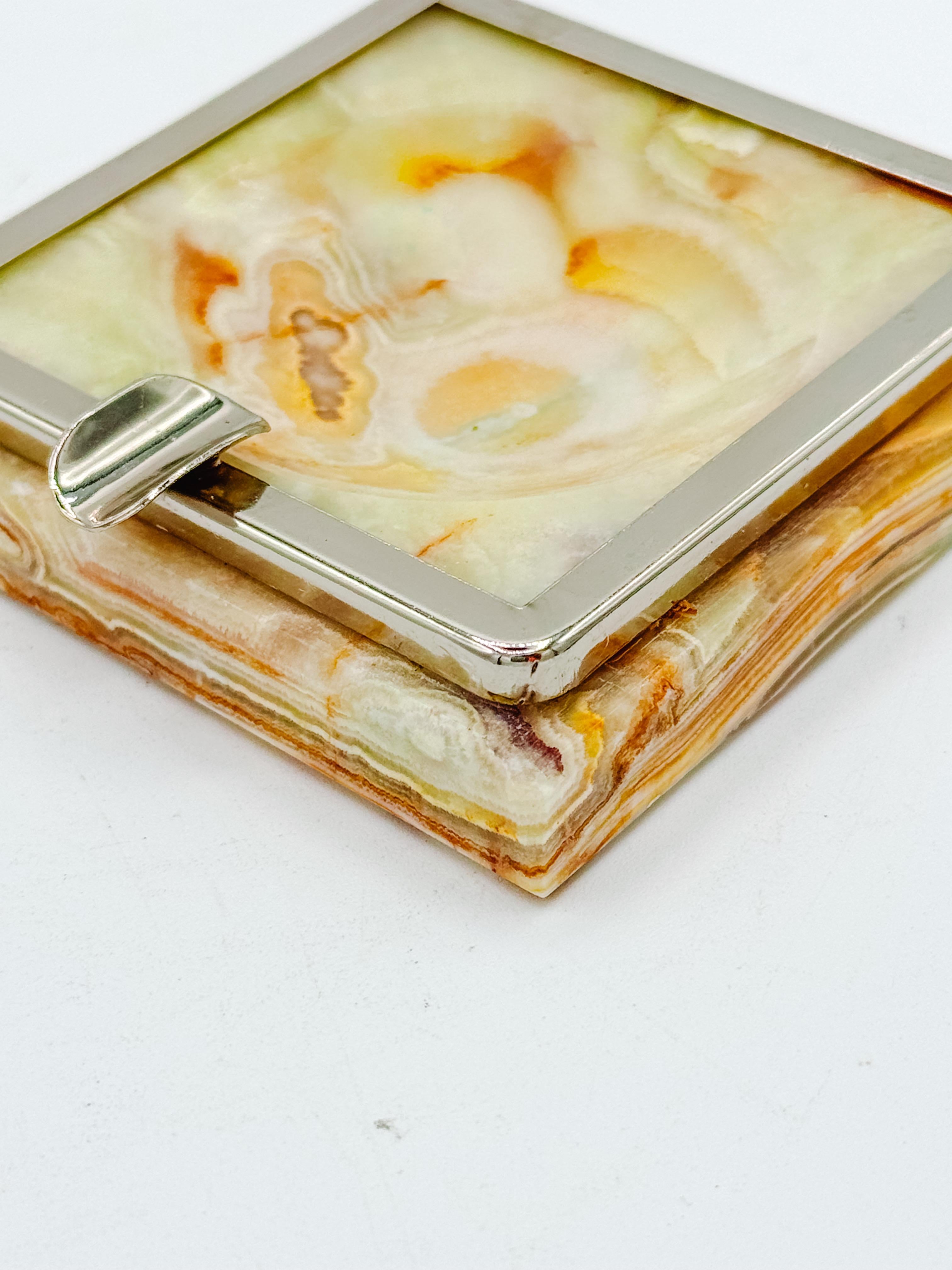 Ce superbe cendrier italien des années 1970 allie admirablement l'élégance naturelle à l'artisanat moderne. La Nature se compose d'une base en onyx massif dans des tons riches de crème, d'ambre et de miel, naturellement veinée de teintes chaudes et