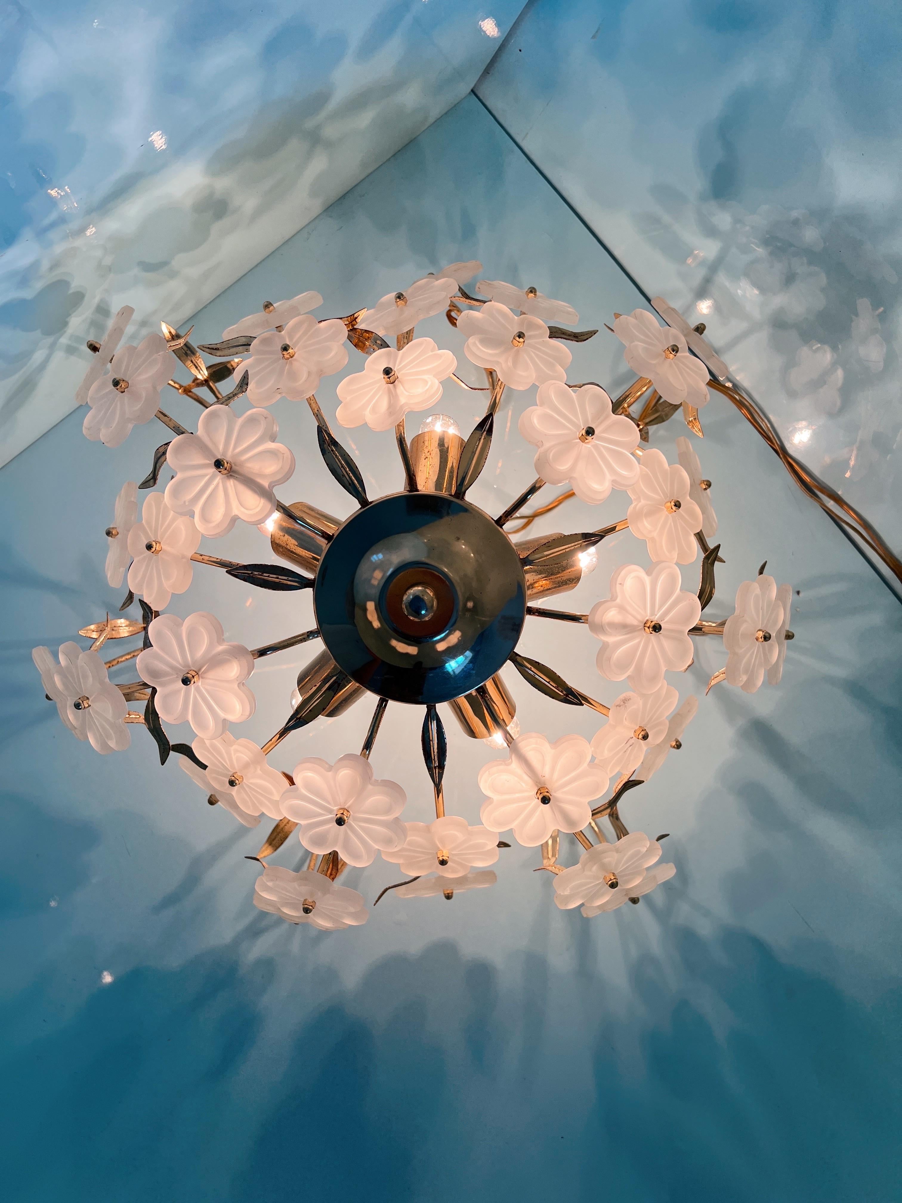 1970s Murano glass flush mount. The cream white Murano glass flowers are set in a beautiful gold-coated metal base adorned with leaves. When lit, it creates a stunning shadow play.