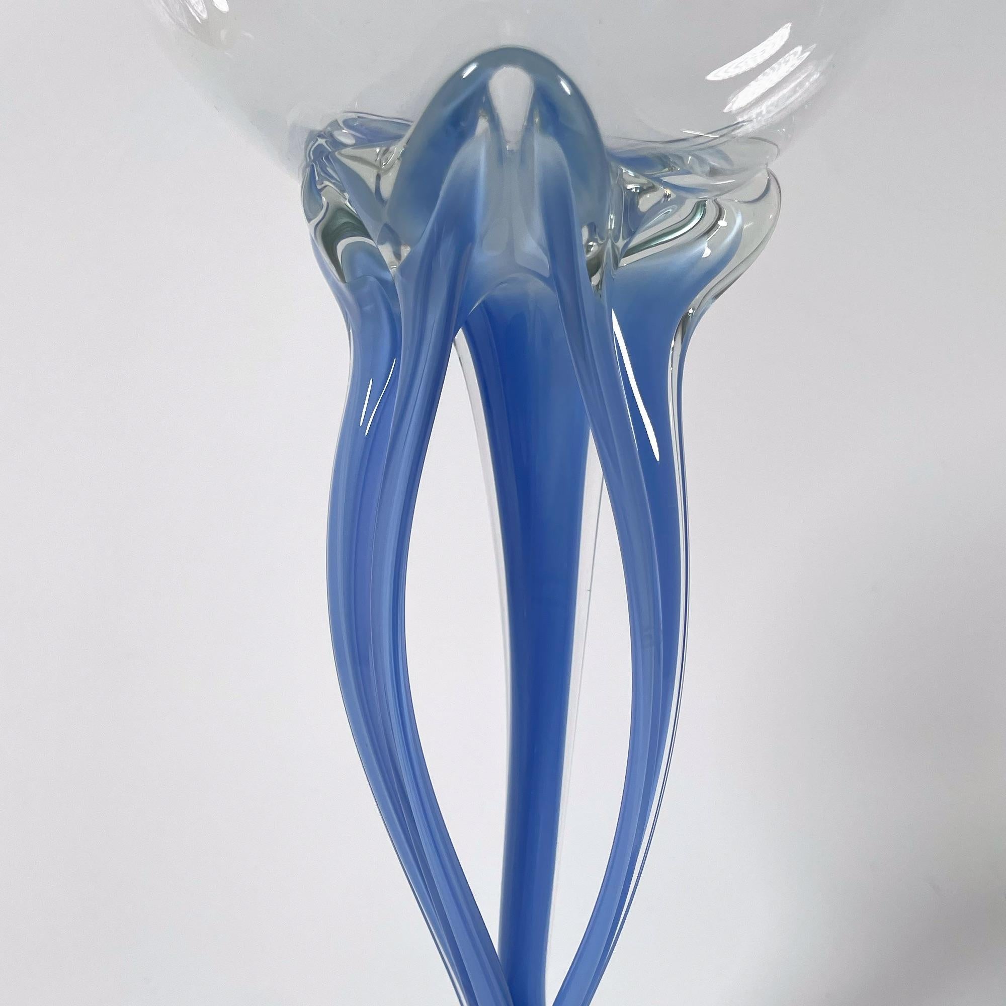 Descubre una impresionante obra de arte con esta exquisita pecera de cristal azul soplado a mano de la década de 1980. Con una altura de 28 cm y un diámetro de 13 cm, este elegante cuenco muestra la artesanía de la cristalería bohemia. El suave tono