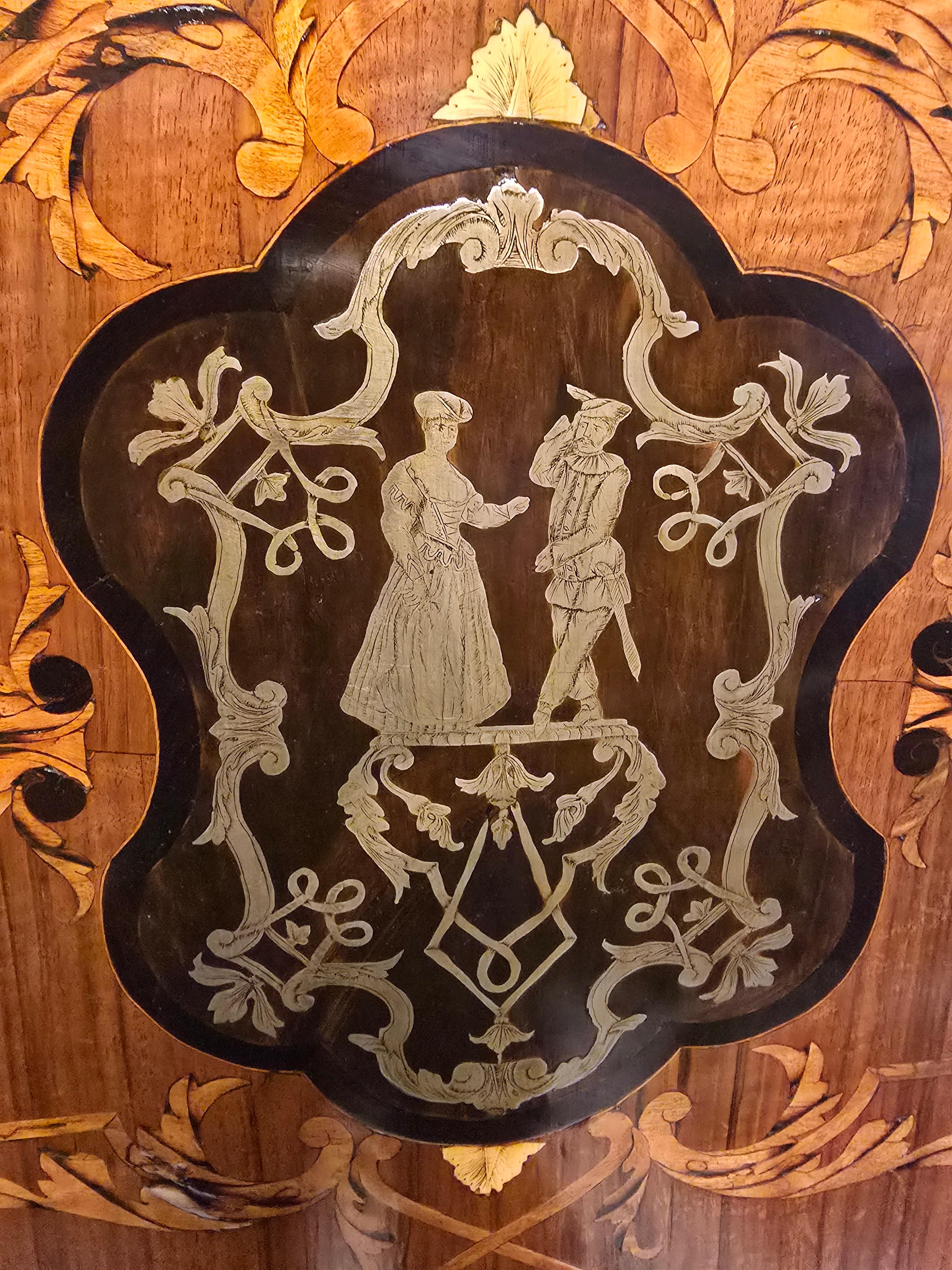 Cette table anglaise raffinée du XIXe siècle illustre l'art de la marqueterie et l'artisanat de l'époque victorienne. Fabriquée en bois exotique et incrustée d'étain, elle présente un plateau de forme ovale pouvant être positionné verticalement,