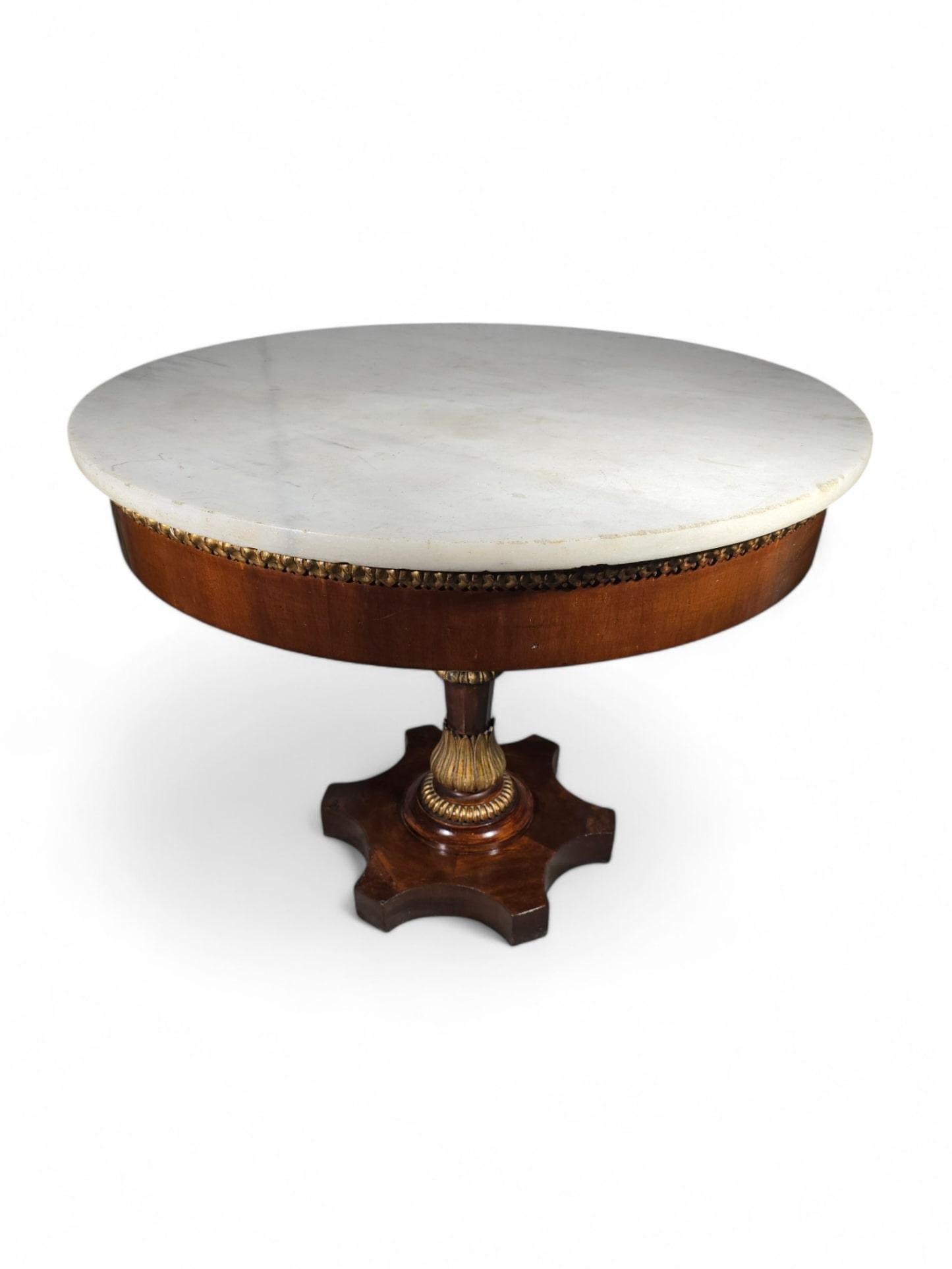 This exquisite 19th-century Italian center table is a stunning example of fine craftsmanship and timeless elegance. The round table features a beautifully carved wooden base, partially gilded to highlight its intricate details, and is topped with a