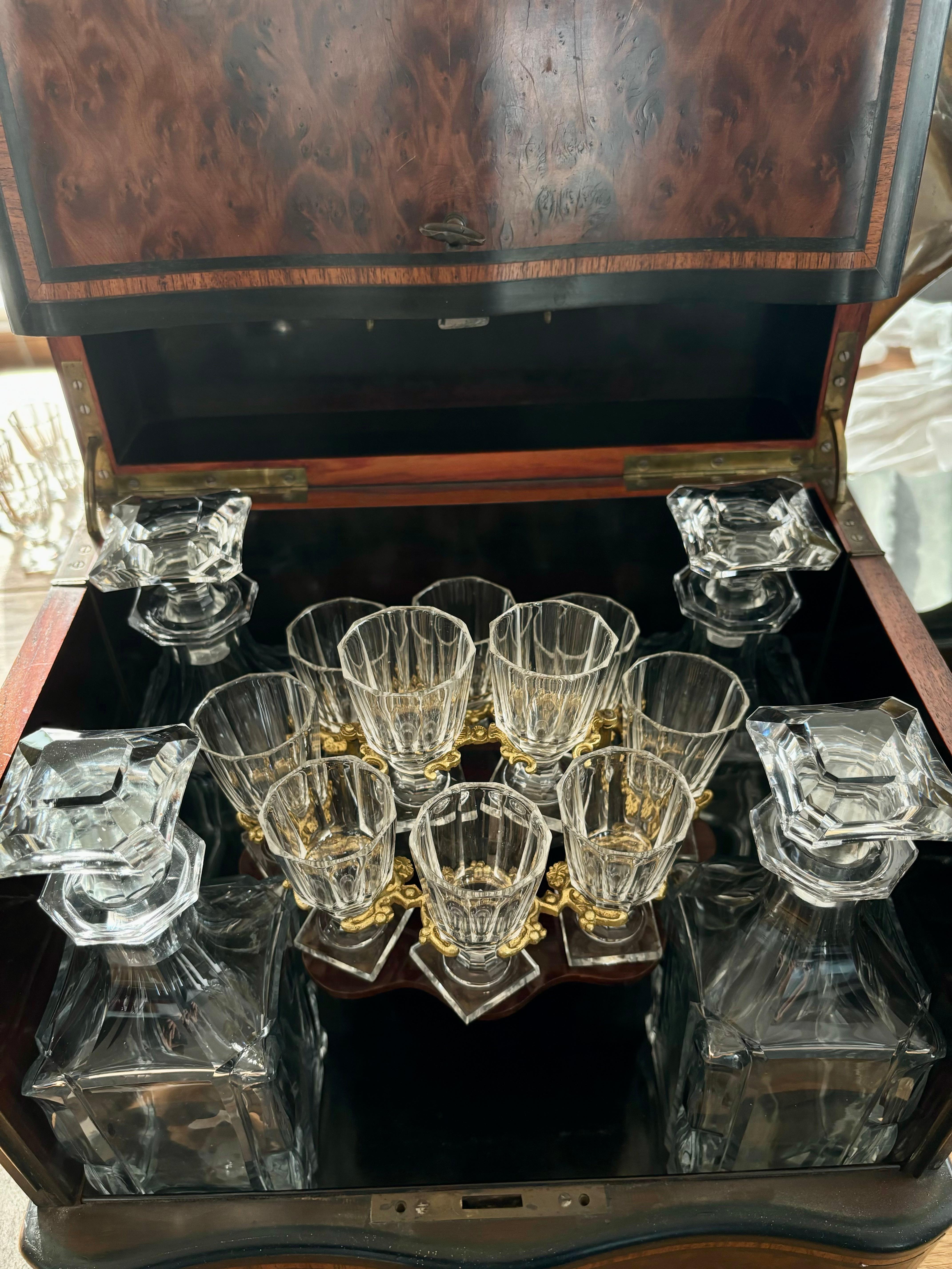 Elegante Napoleón III del siglo XIX, cueva de cristal completa para licores. 

El juego consta de 4 decantadores de cristal y 13 copas de cristal en una inserción extraíble de palisandro y latón. La caja probablemente sea de caoba con acabados de
