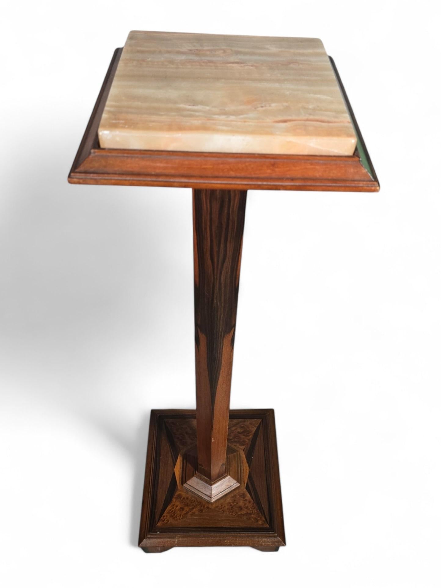 A refined and sophisticated pedestal from circa 1900, crafted from exotic wood and adorned with a polished onyx top. This piece exudes timeless elegance, making it a perfect addition to any interior or gallery display.

Features:

Era: Late 19th