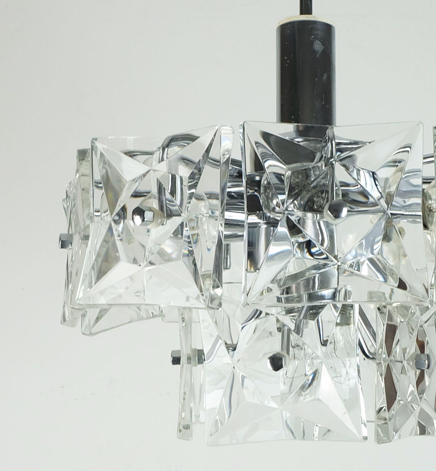 Lampada a sospensione molto bella ed elegante prodotta negli anni '60 da Kinkeldey. Realizzato in metallo cromato e vetro di cristallo. Il paralume è composto da 14 prismi di vetro sfaccettati (3,93