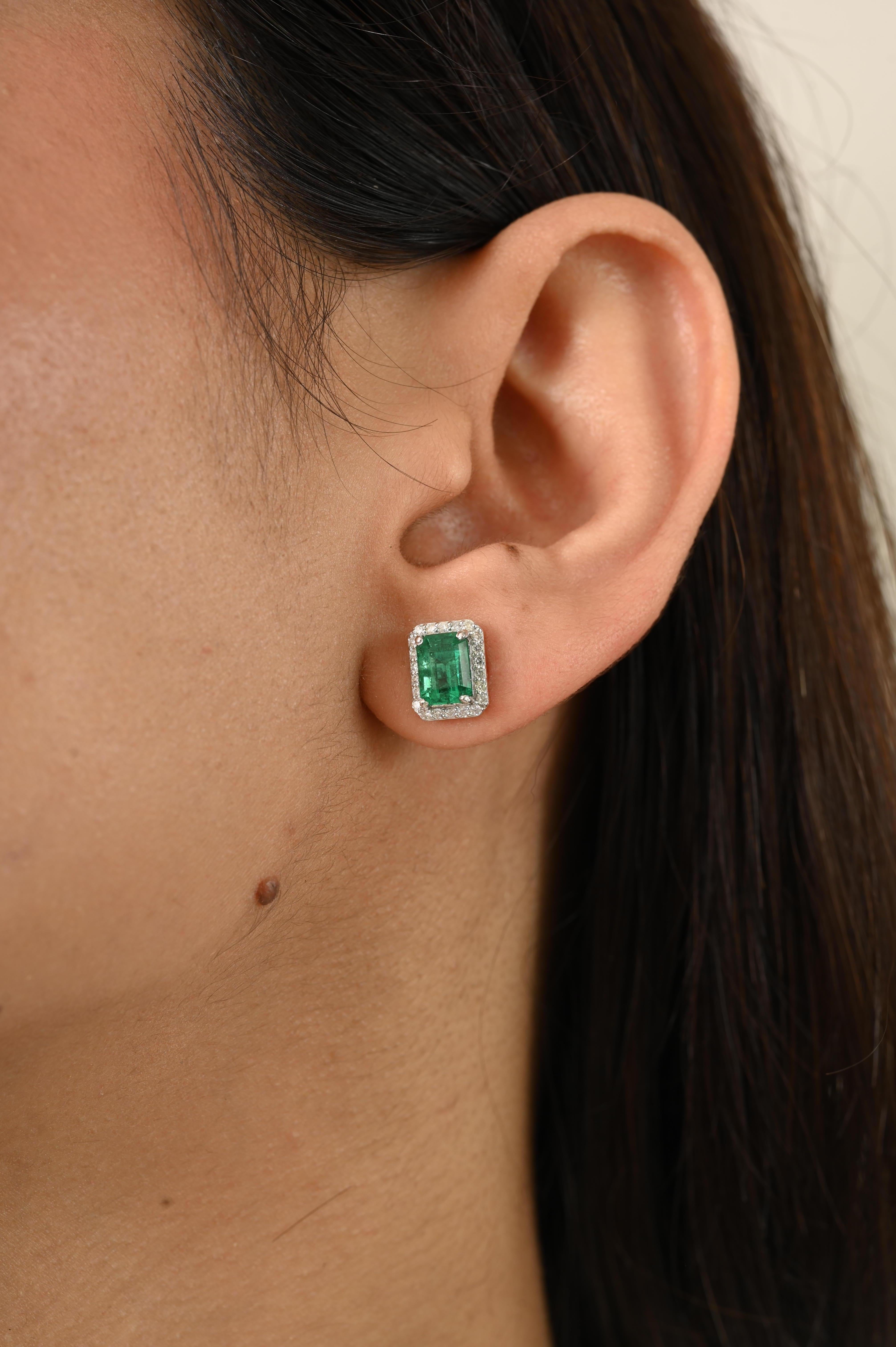 Timeless Emerald-Cut Emerald and Diamond Halo Stud Earrings in 14k White Gold, showcasing a total stone weight of 2.09 carats accented by 0.29 carats of sparkling diamonds. Emerald is cut to perfection and framed by a brilliant diamond halo, these