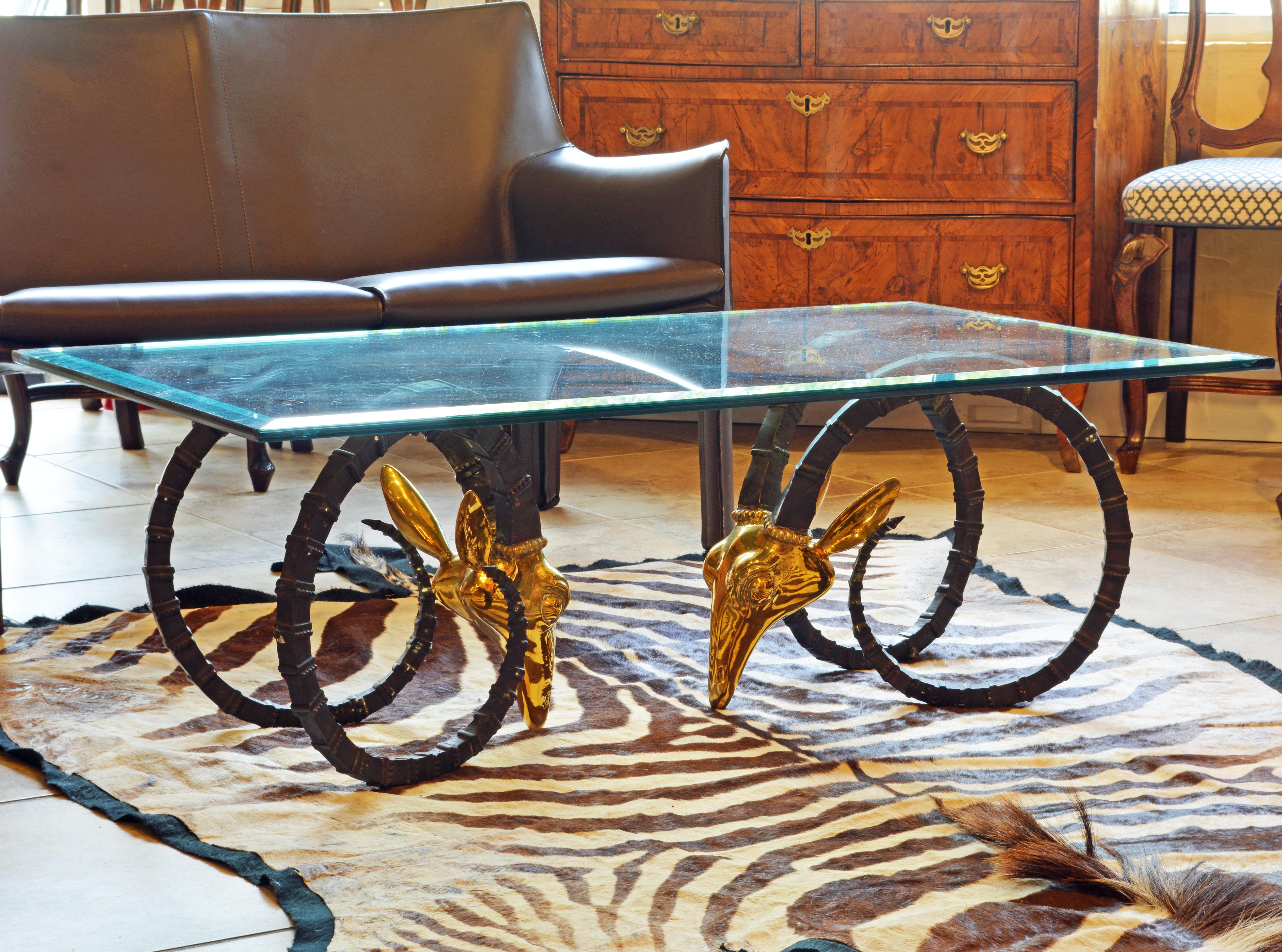 French 20th century brass ibex head coffee table in the Hollywood Regency style attributed to Alain Chervet. The coffee table has two sculpted ibex or ram’s heads made of heavy solid polished brass with long sculpted and dark patinated horns and