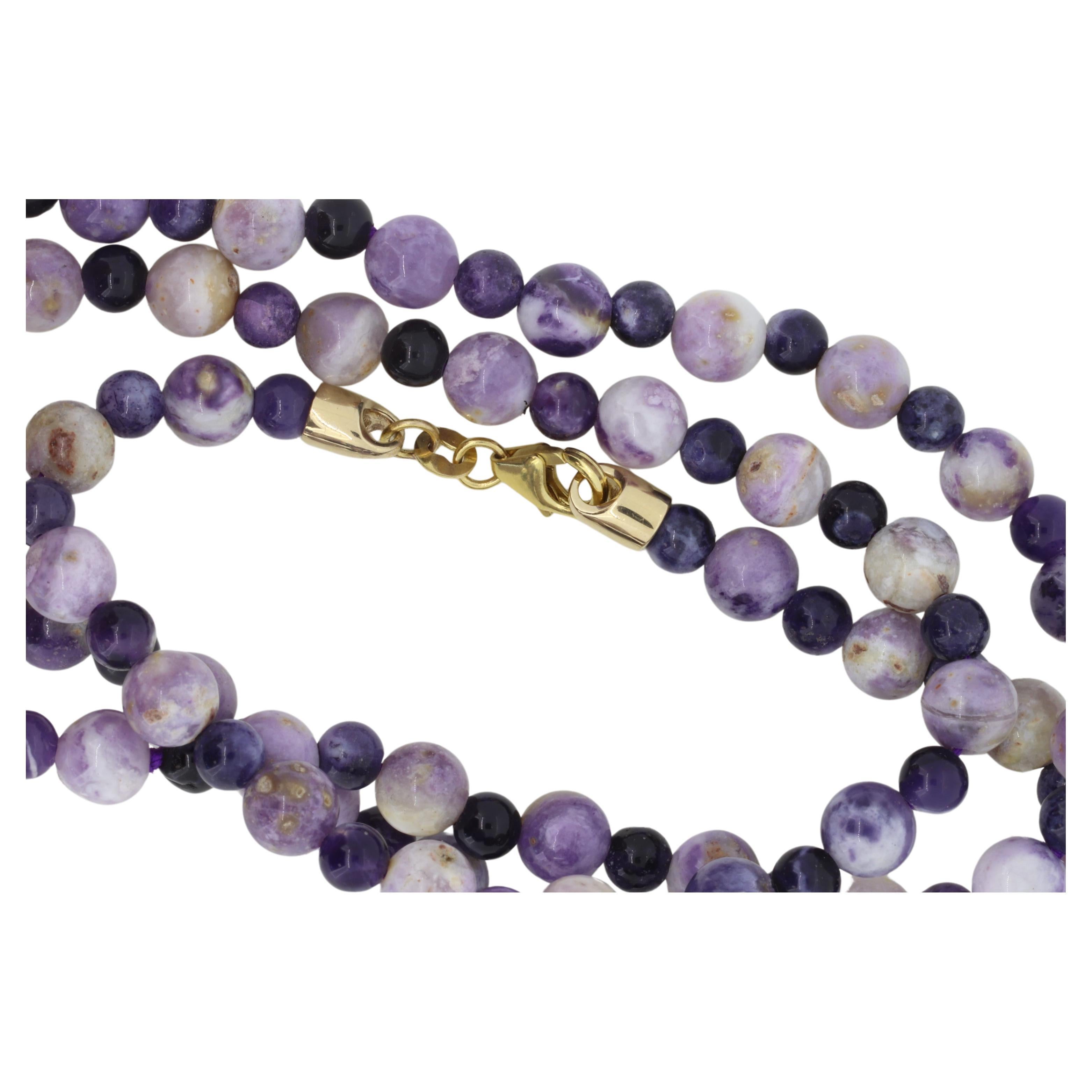 Elegante e vibrante, questa splendida collana di gemme multicolore rotonda di 24 pollici è una vera e propria celebrazione del colore e dell'artigianato. Realizzate a mano con perline dai toni ricchi di viola, lavanda e prugna intenso, ogni pietra è