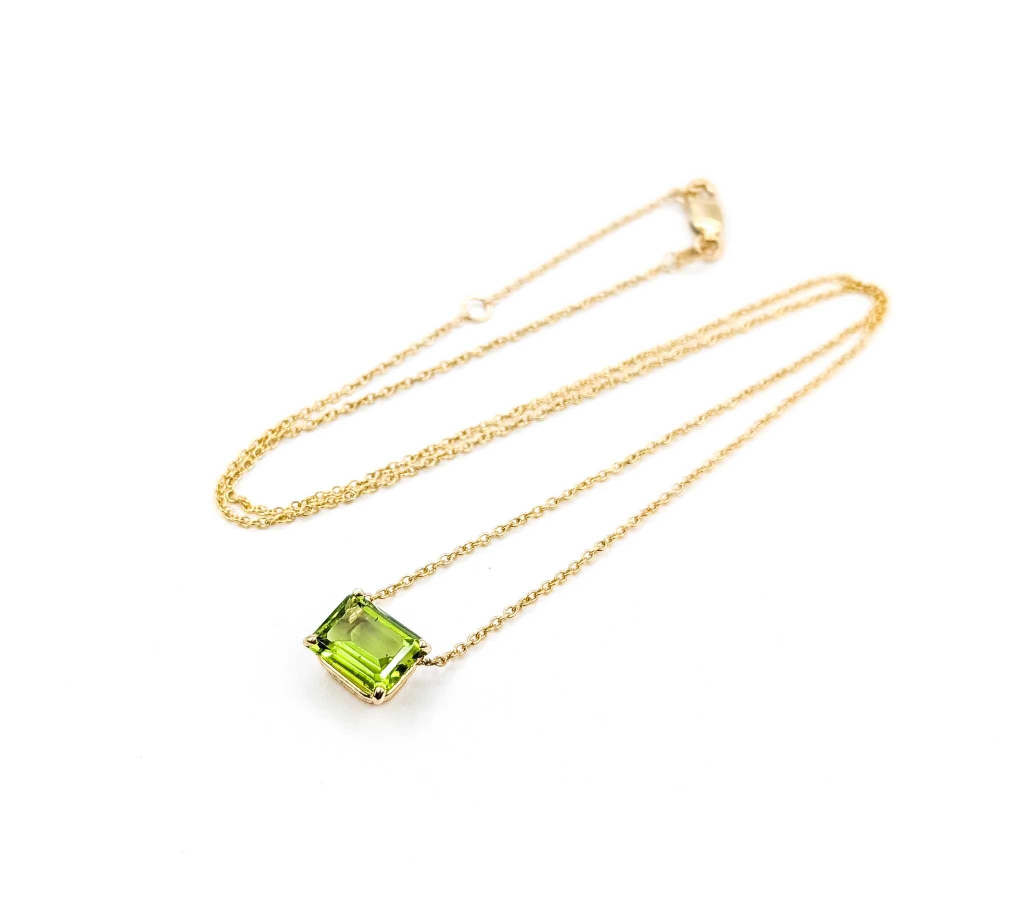 Questa splendida collana presenta un vibrante peridoto da 2,45 carati, saldamente incastonato in una classica montatura a quattro punte in oro giallo 14k. Il taglio a gradini rettangolare del peridoto mette in risalto la sua vivace tonalità verde e