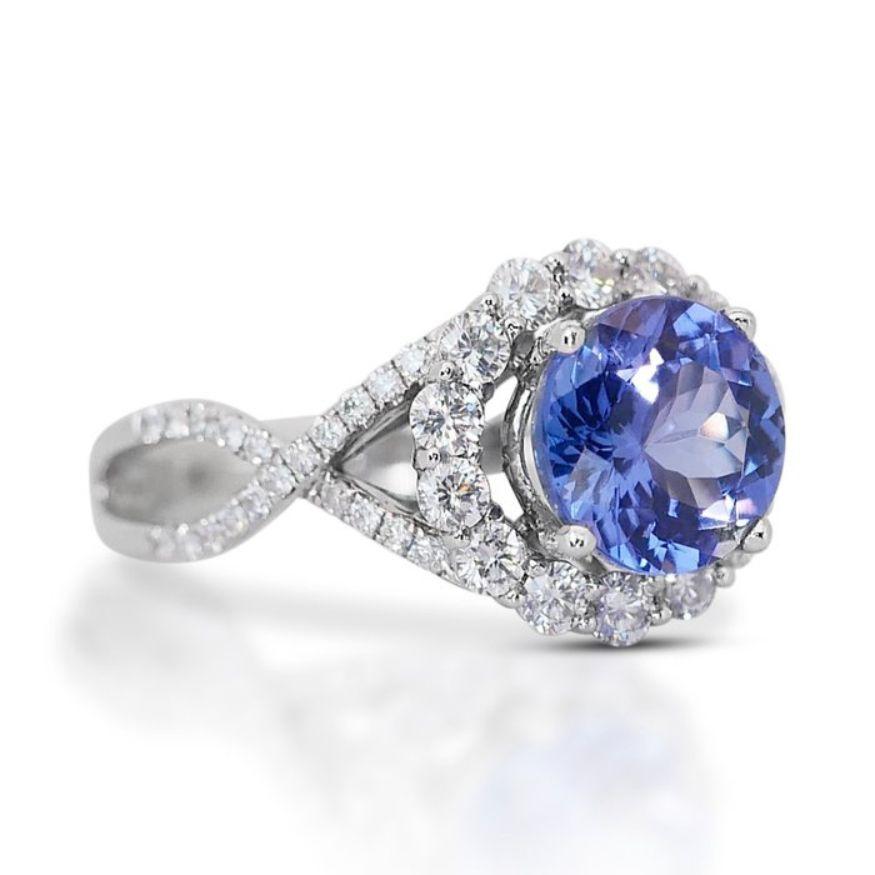 This exquisite ring features a stunning Tanzanite as its centerpiece, boasting a magnificent 2.80 carat round mixed cut stone. Displaying a captivating Deep Violetish Blue hue, the Tanzanite exudes elegance and allure. Its transparency adds a sense
