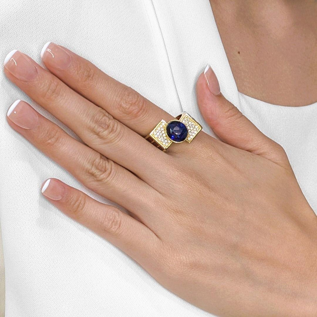 A masterpiece of regal elegance, this exquisite 18K yellow gold ring boasts a stunning 5.98-carat oval sapphire, radiating deep blue brilliance at its center. Framing this magnificent gemstone, 21 princess-cut emeralds (1.56ct) and 21 princess-cut