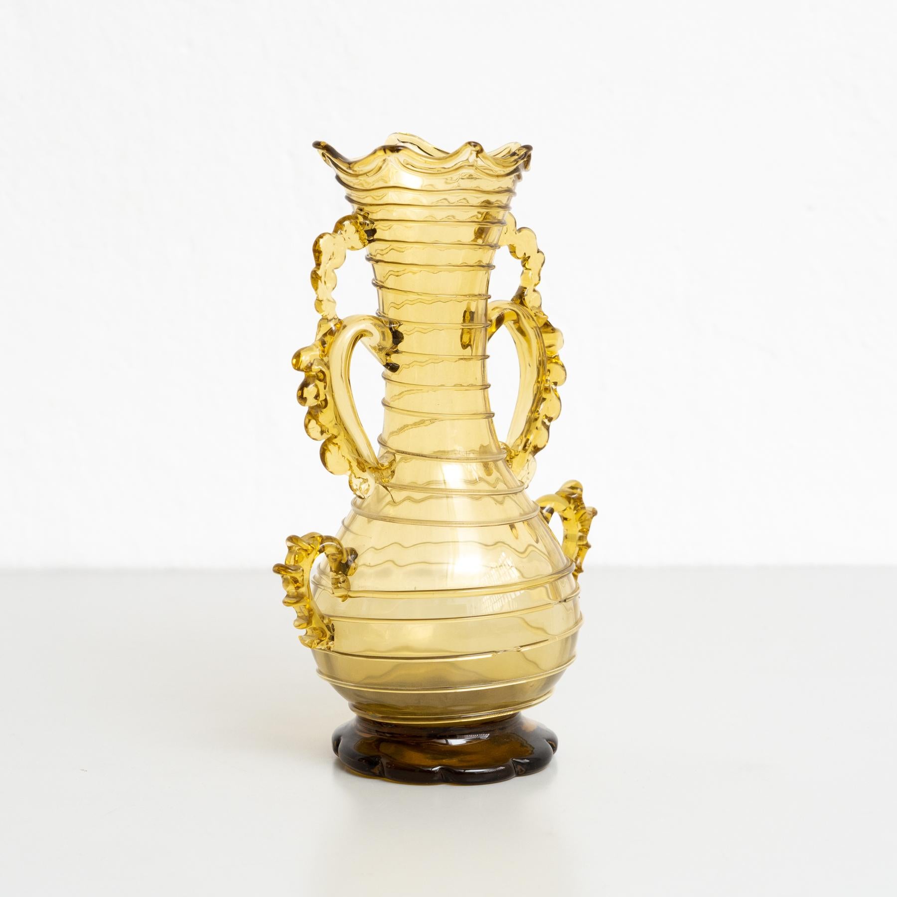 Rehaussez votre décor avec l'élégance intemporelle de ce vase vintage en verre soufflé ambré du début du 20e siècle. Fabriqué par un fabricant espagnol inconnu, ce vase conserve son état d'origine, avec une gracieuse usure mineure qui reflète son