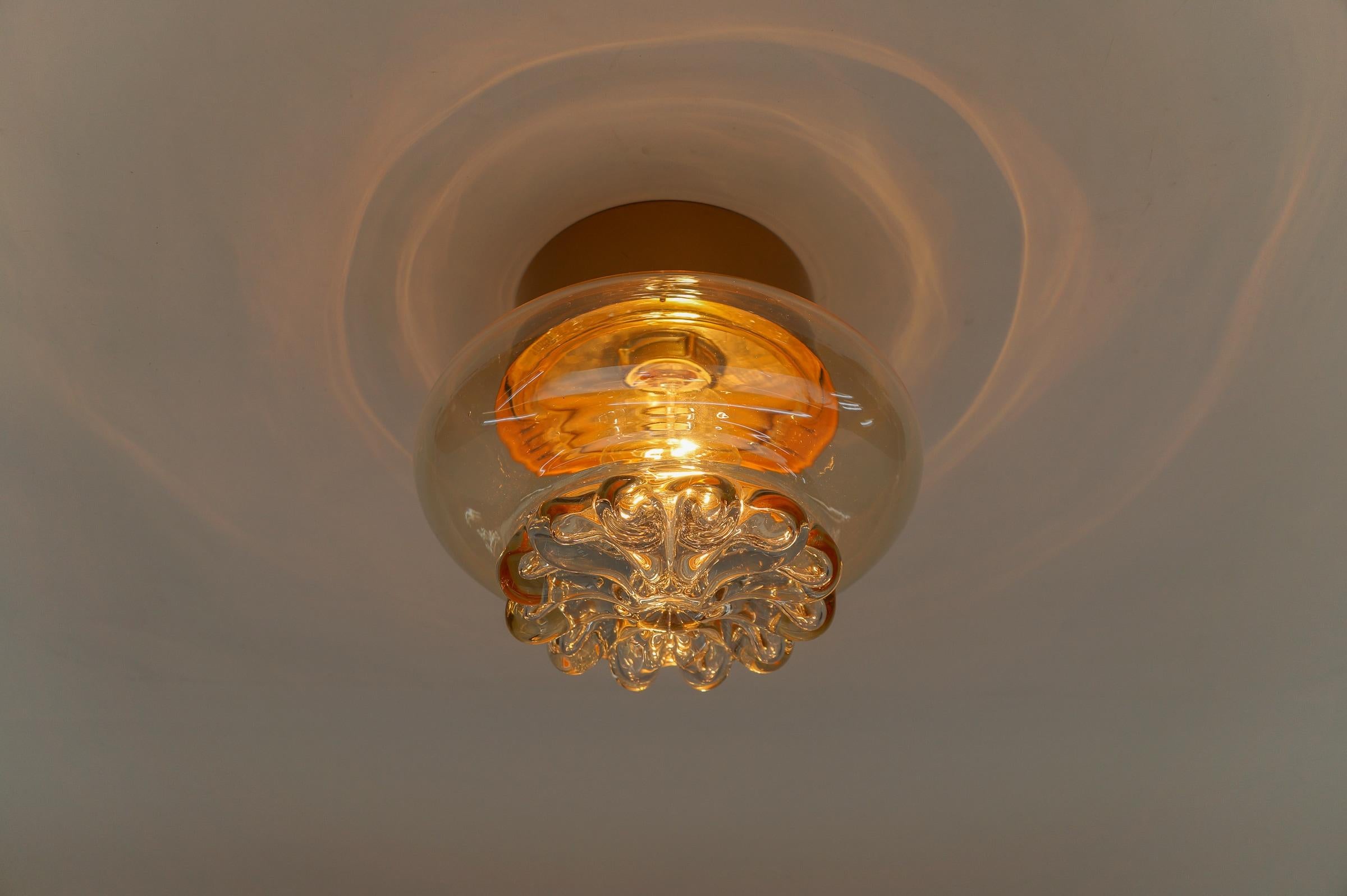 Elegant Amber Glass Flush Mount by Limburg, Germany 1960s

Dimensions
Height: 7.08 in. (18 cm)
Diameter: 8.66 in. (22 cm)

The fixture need 1 x E27 standard bulb with 60W max.

Light bulbs are not included.
It is possible to install this fixture in