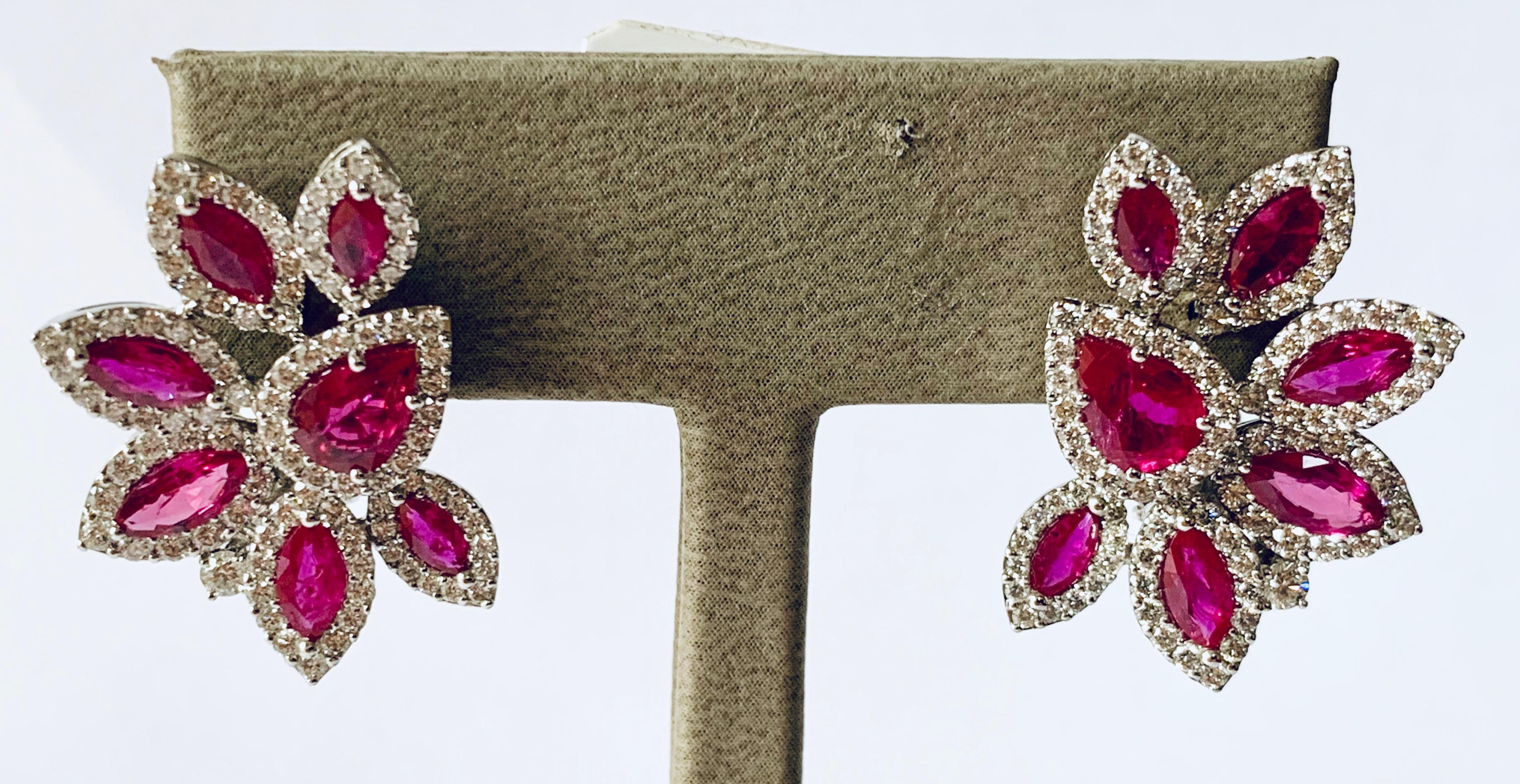 A very beautiful and elegant pair of wearable ruby and diamond cluster earrings. Set with 14 Rubies weighing 4.39 ct and 200 brilliant cut diamonds weighing 2.23 ct, G, vs. Omega clip with post. 