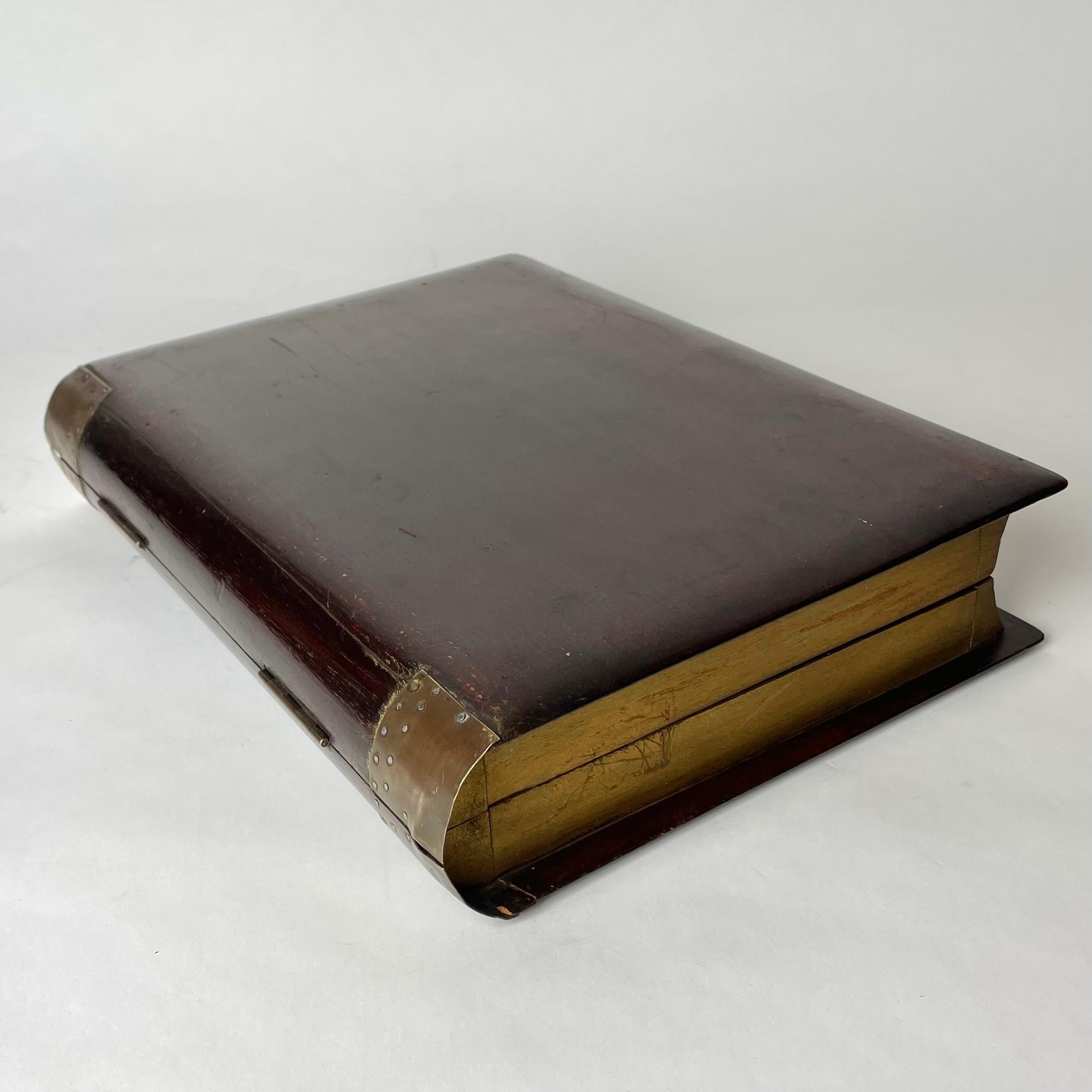 Boîte élégante et décorative en forme de grand livre du début du 20e siècle. Fabriqué en Beeche avec des détails en laiton et des pages dorées.

Usure correspondant à l'âge et à l'usage. 